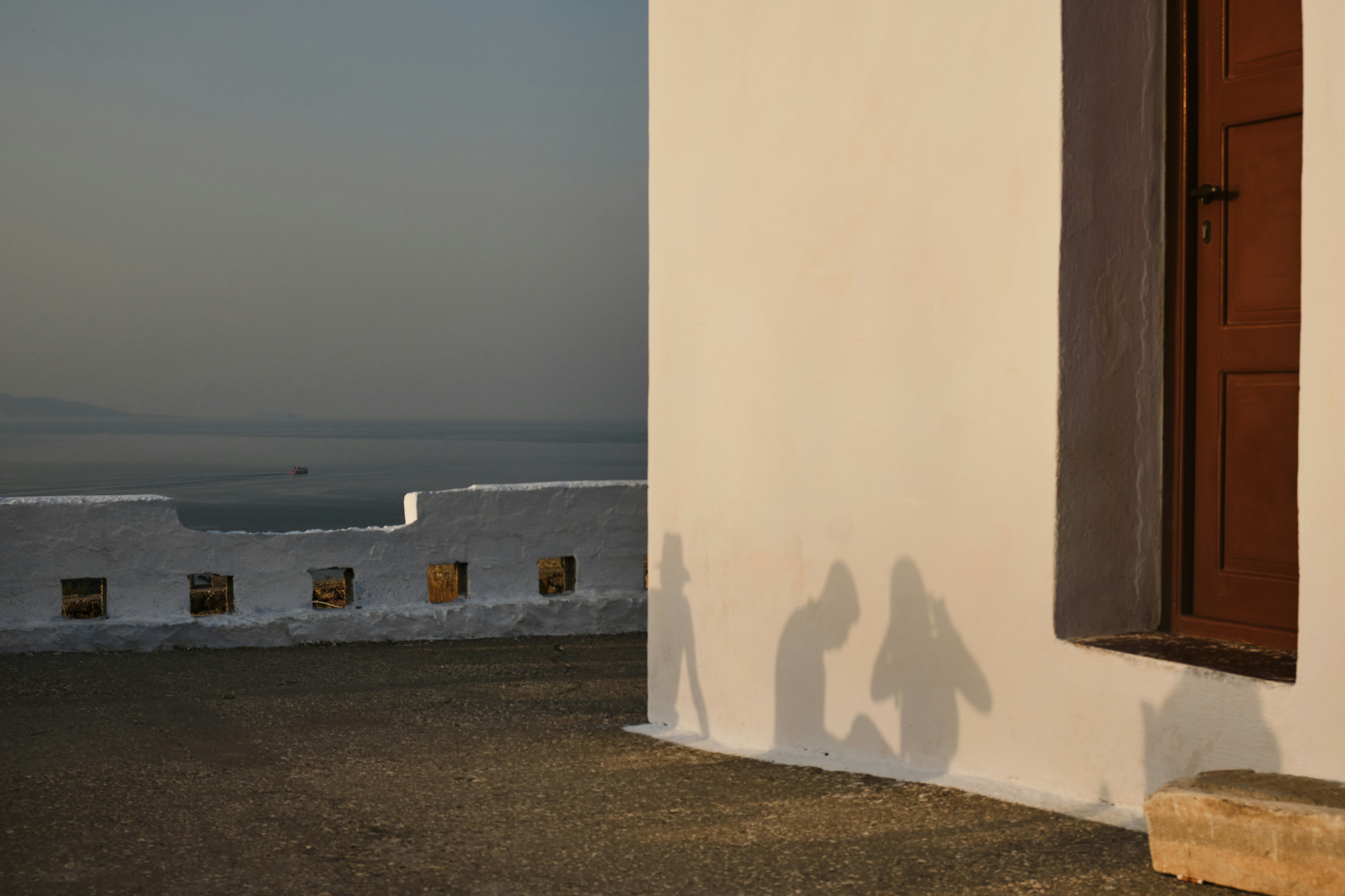 Schatten von Menschen werden auf die Wand eines Gebäudes geworfen.