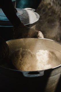 Steaming rice being served from a large pot.