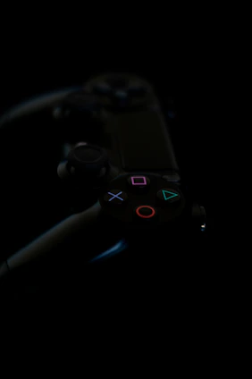 A playstation controller sits in the darkness.