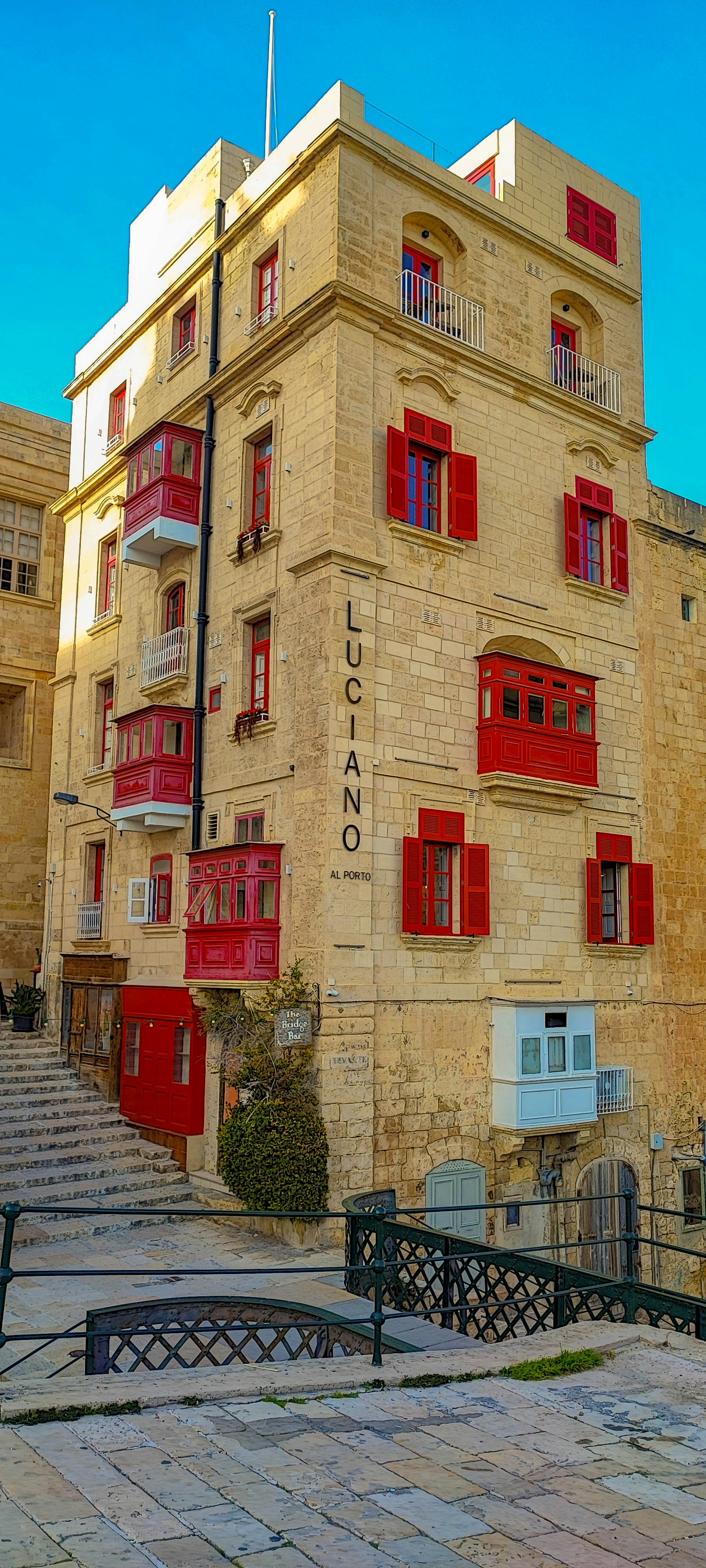 A tall building with red shutters and balconies.
