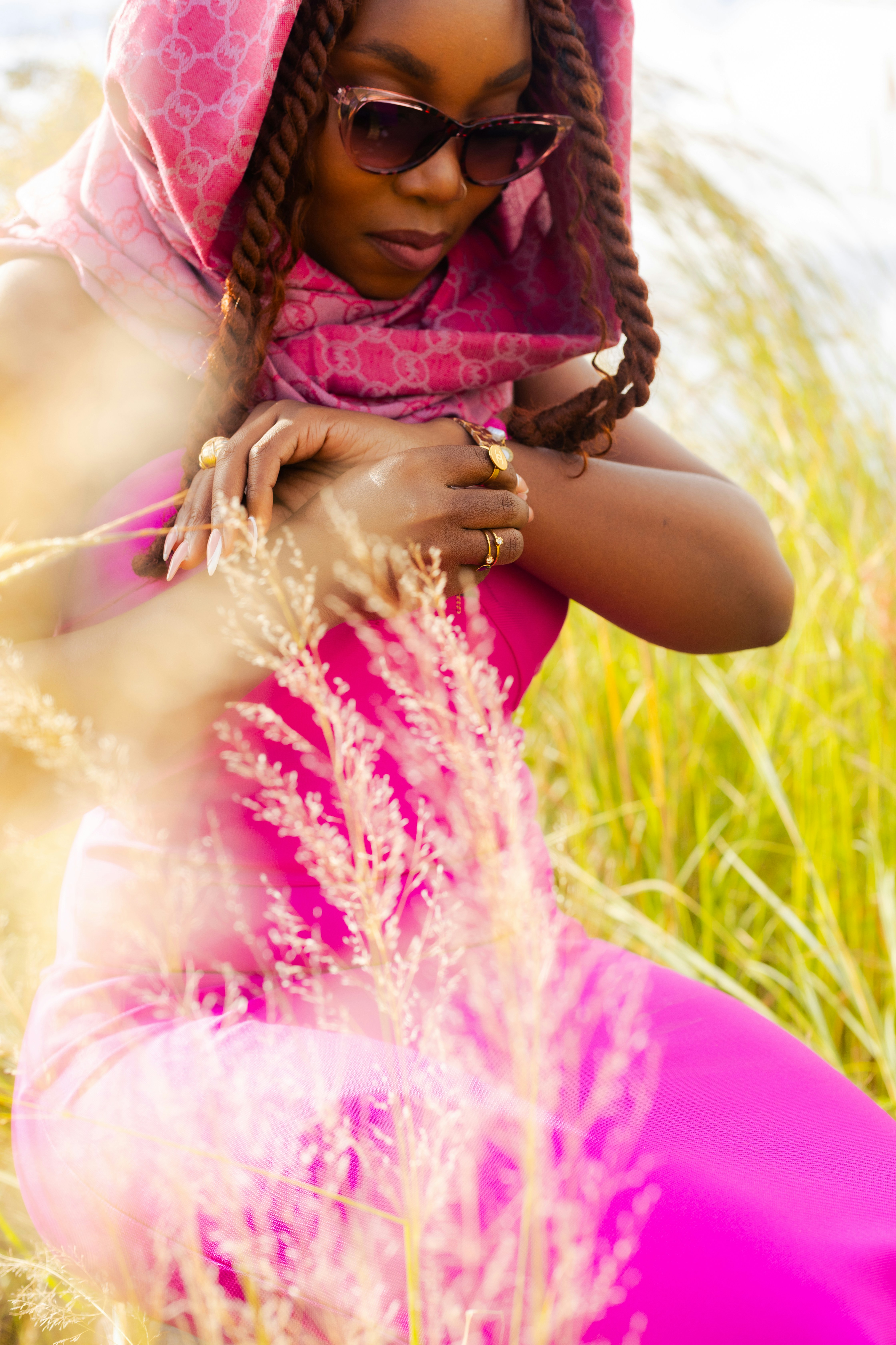 Woman in pink poses gracefully outdoors.