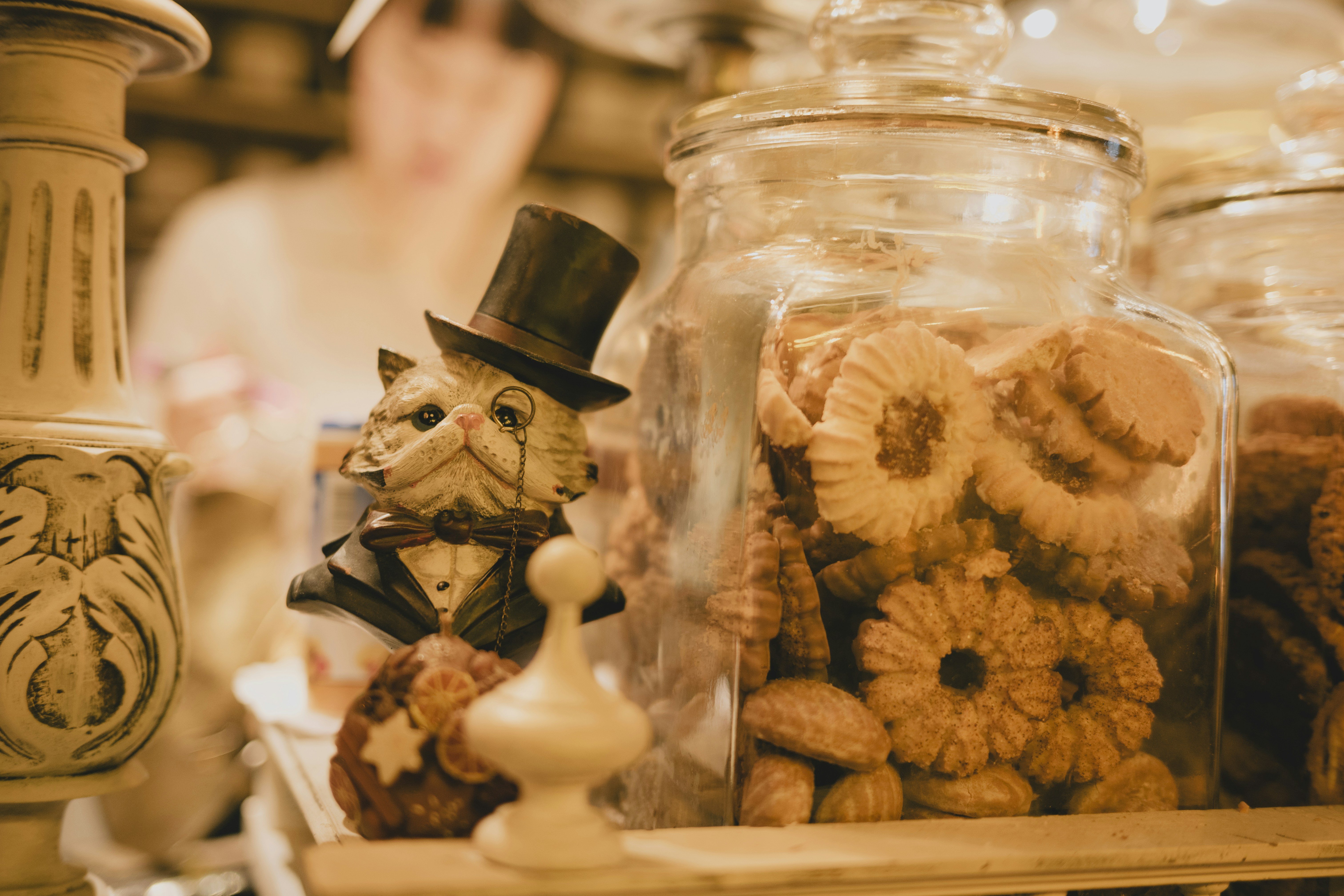A cat statue and cookies sit together.