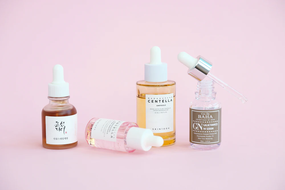 Flacons de soins dermatologiques sur fond rose poudré