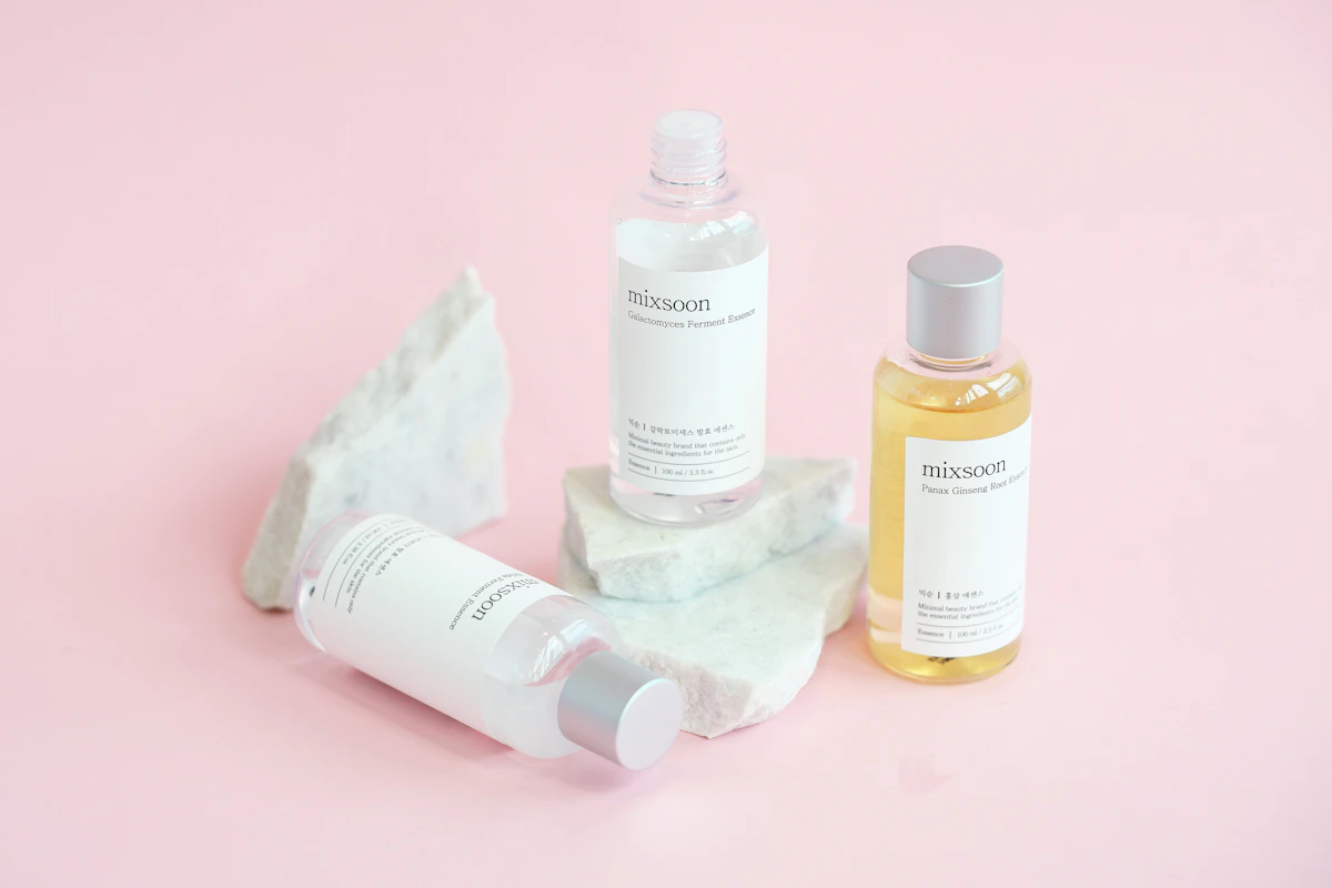 Amber skincare bottles and droppers displayed on smooth marble rocks