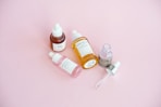Skincare serum bottles arranged on a pink surface.