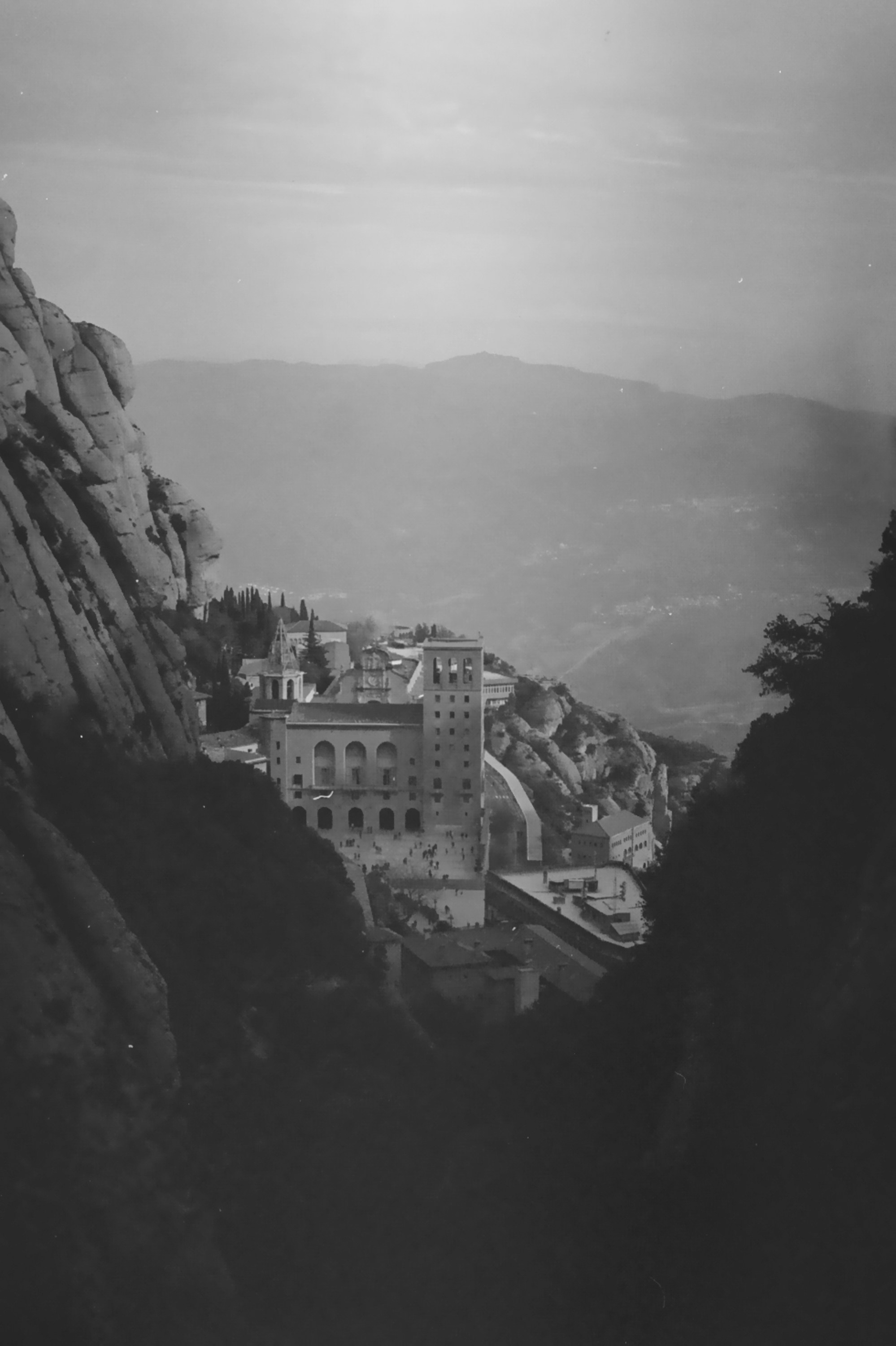 Monastery nestled between rocky mountain cliffs.
