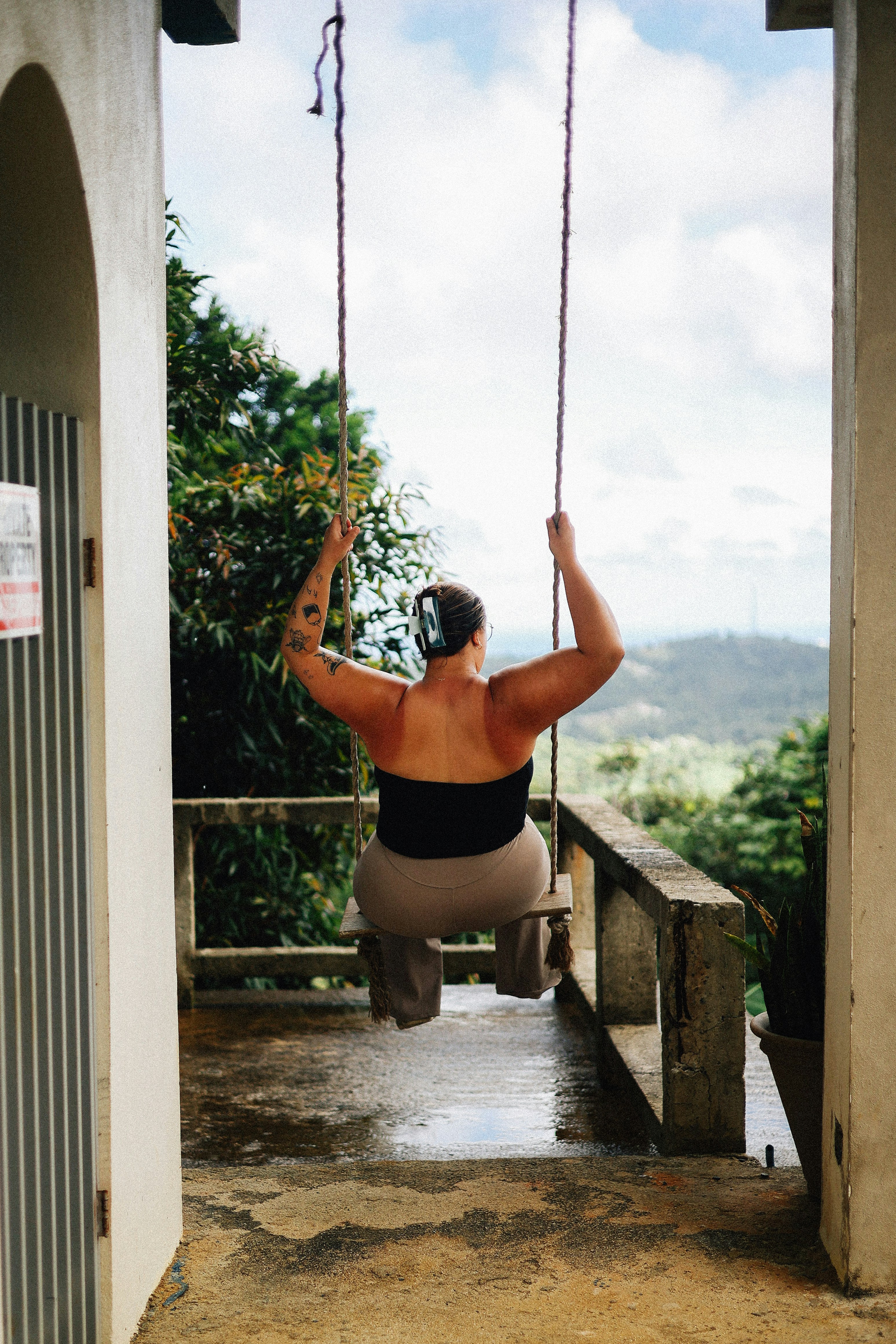 Woman enjoys the view while swinging outside.