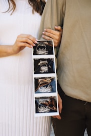 Couple excitedly shows their ultrasound pictures.