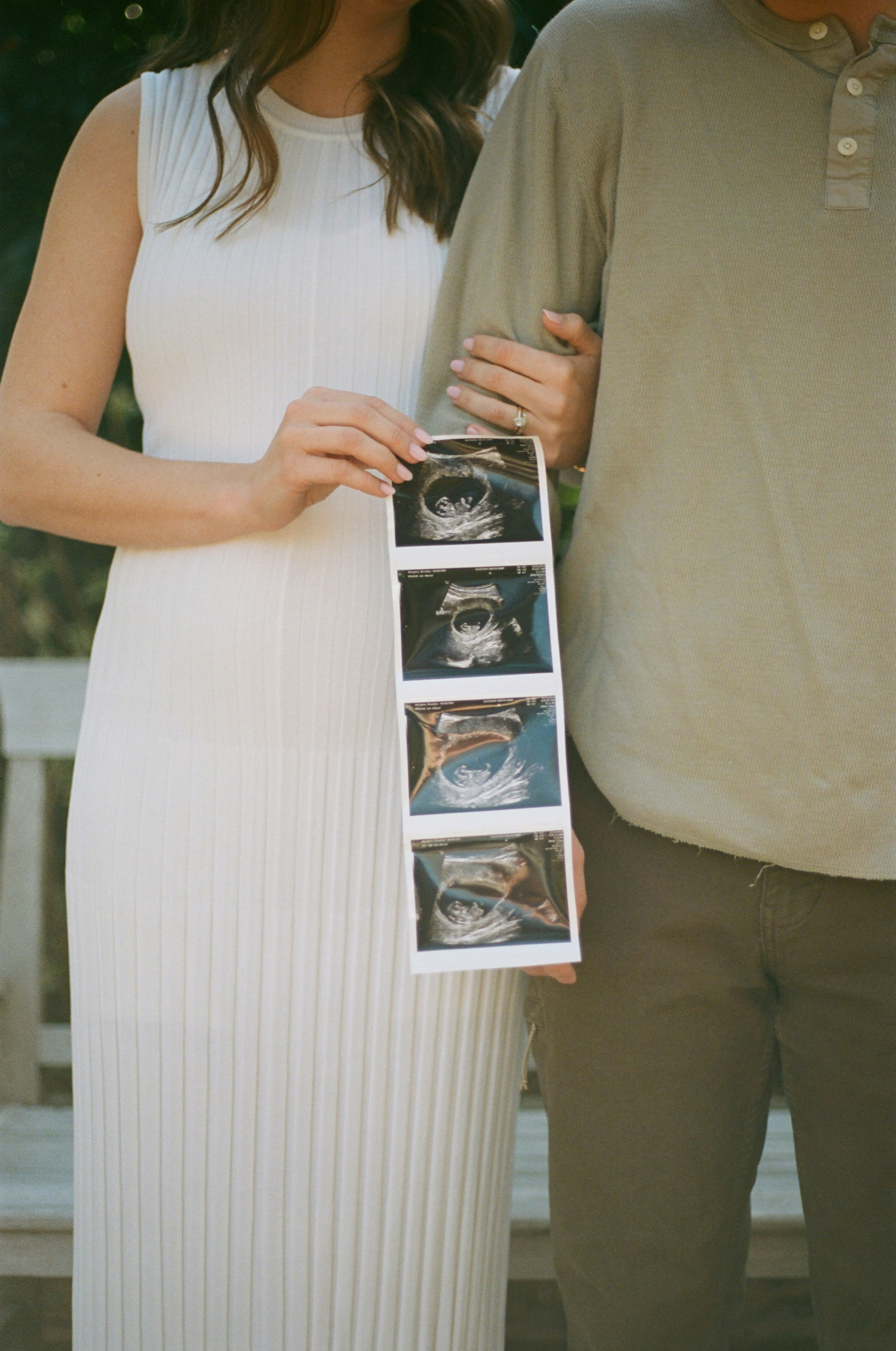 Expecting parents show off ultrasound images.