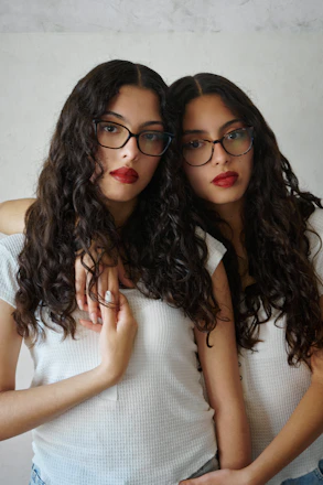 Two beautiful women wearing matching glasses.