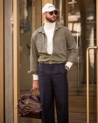 Man wearing stylish outfit standing outside a building.