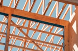 Wooden framework of a building against a blue sky.