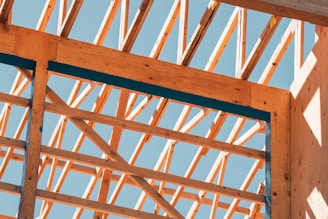 Wooden framework of a building against a blue sky.
