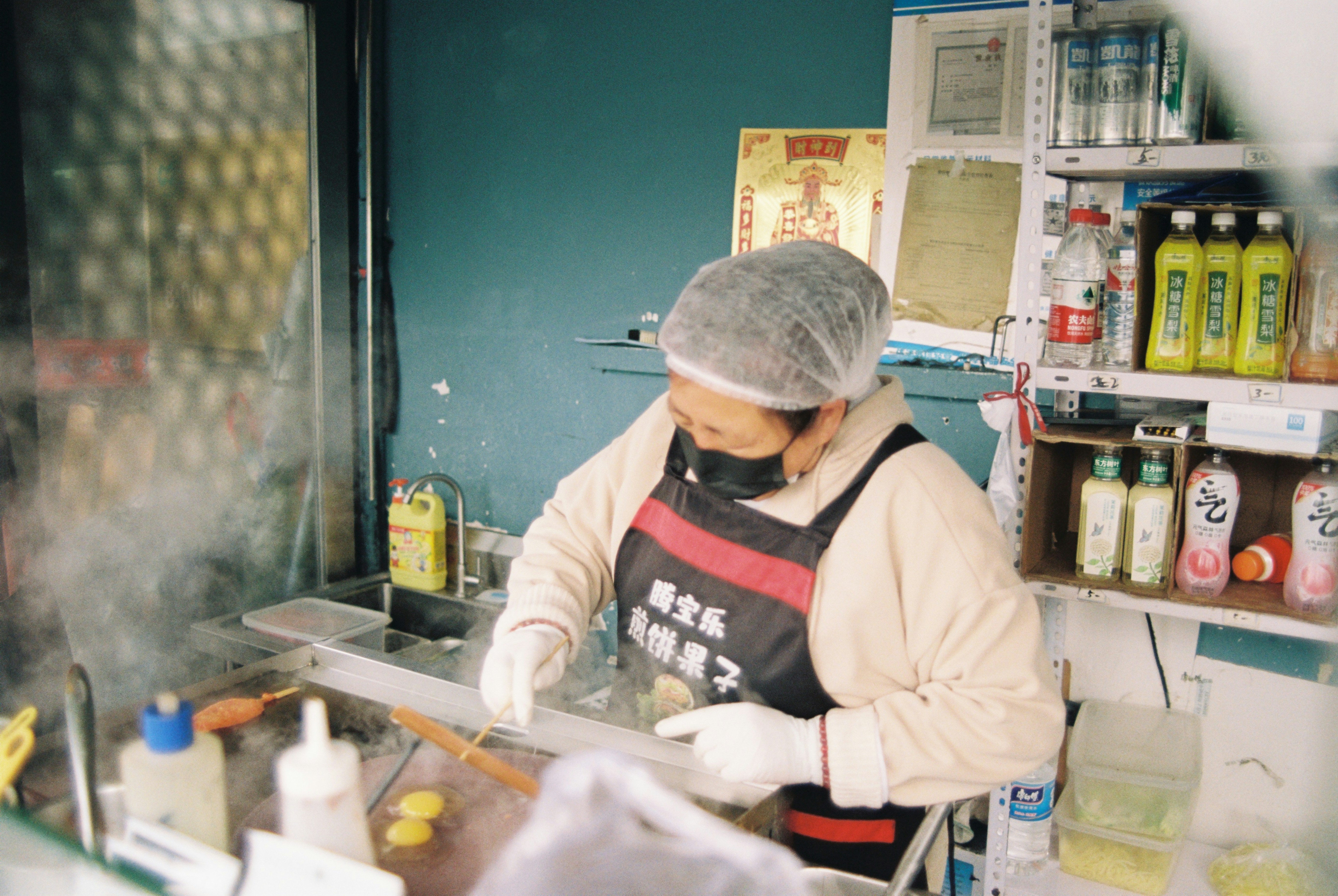A cook prepares food behind a counter.