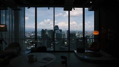 Room with a breathtaking cityscape view through windows.