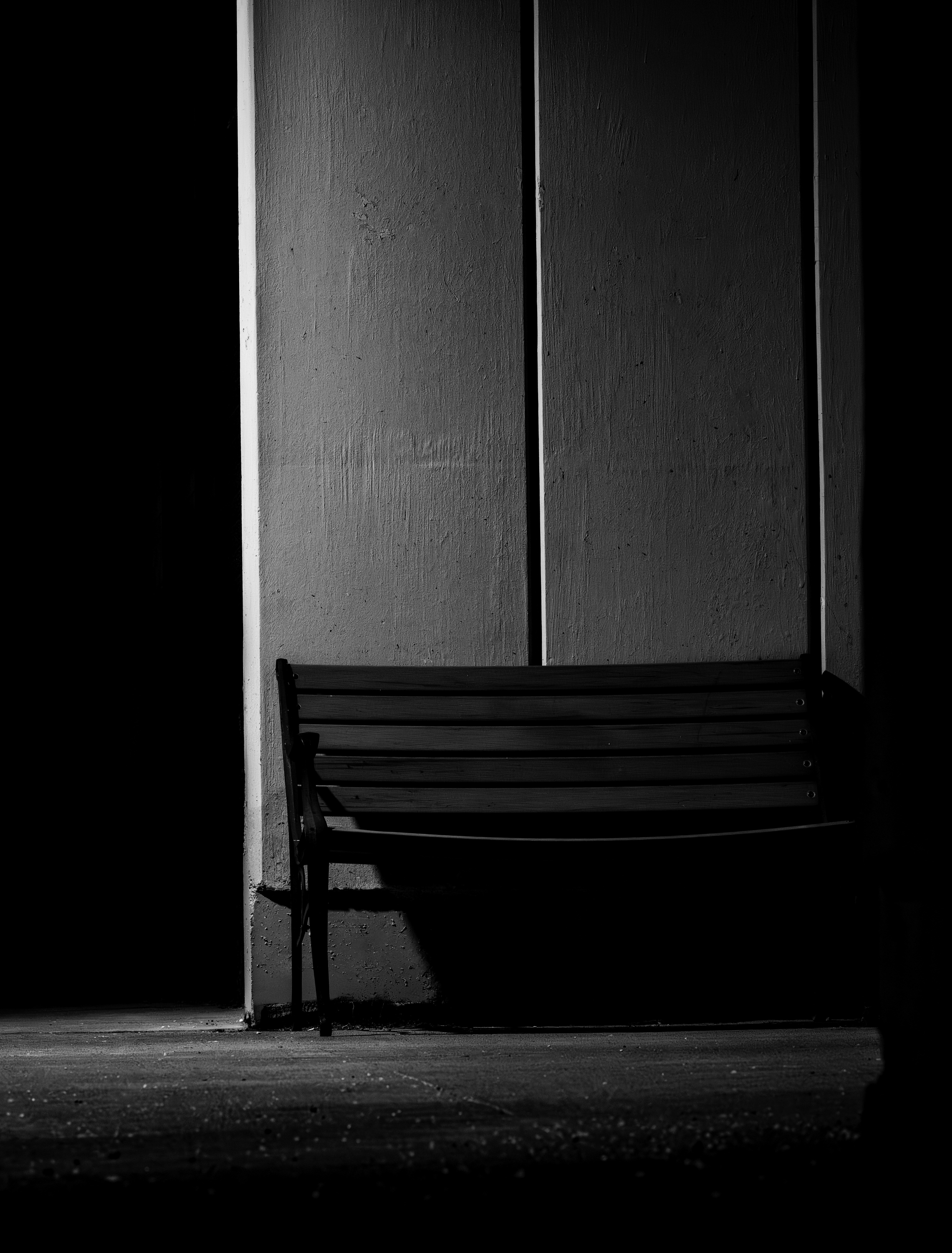 A lonely bench sits in the darkness.