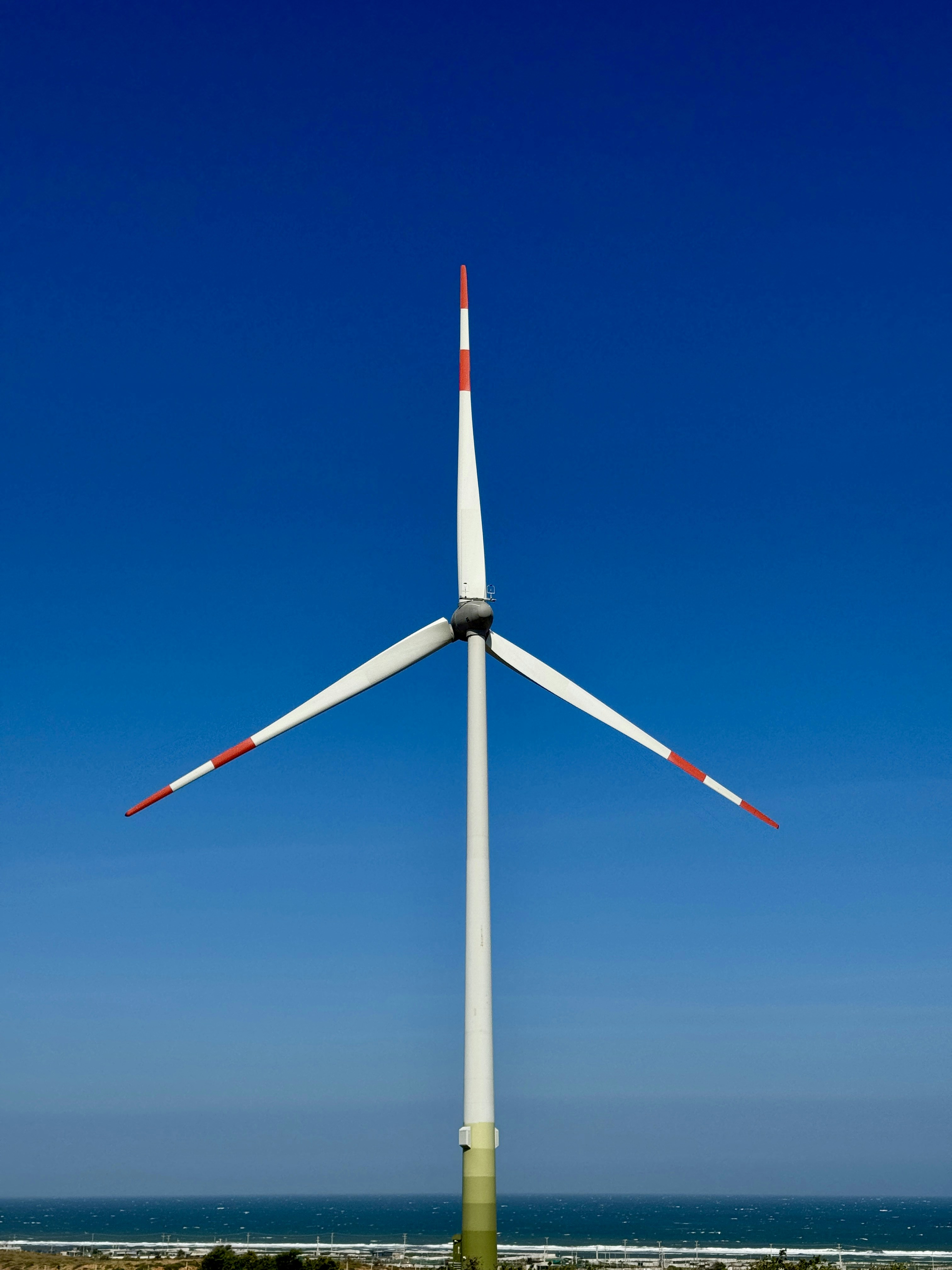 Wind turbine against a bright blue sky.