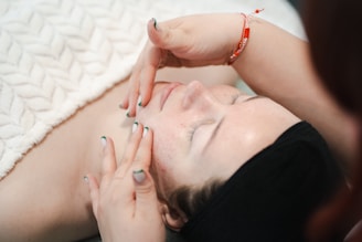 Woman enjoying a facial massage with closed eyes.