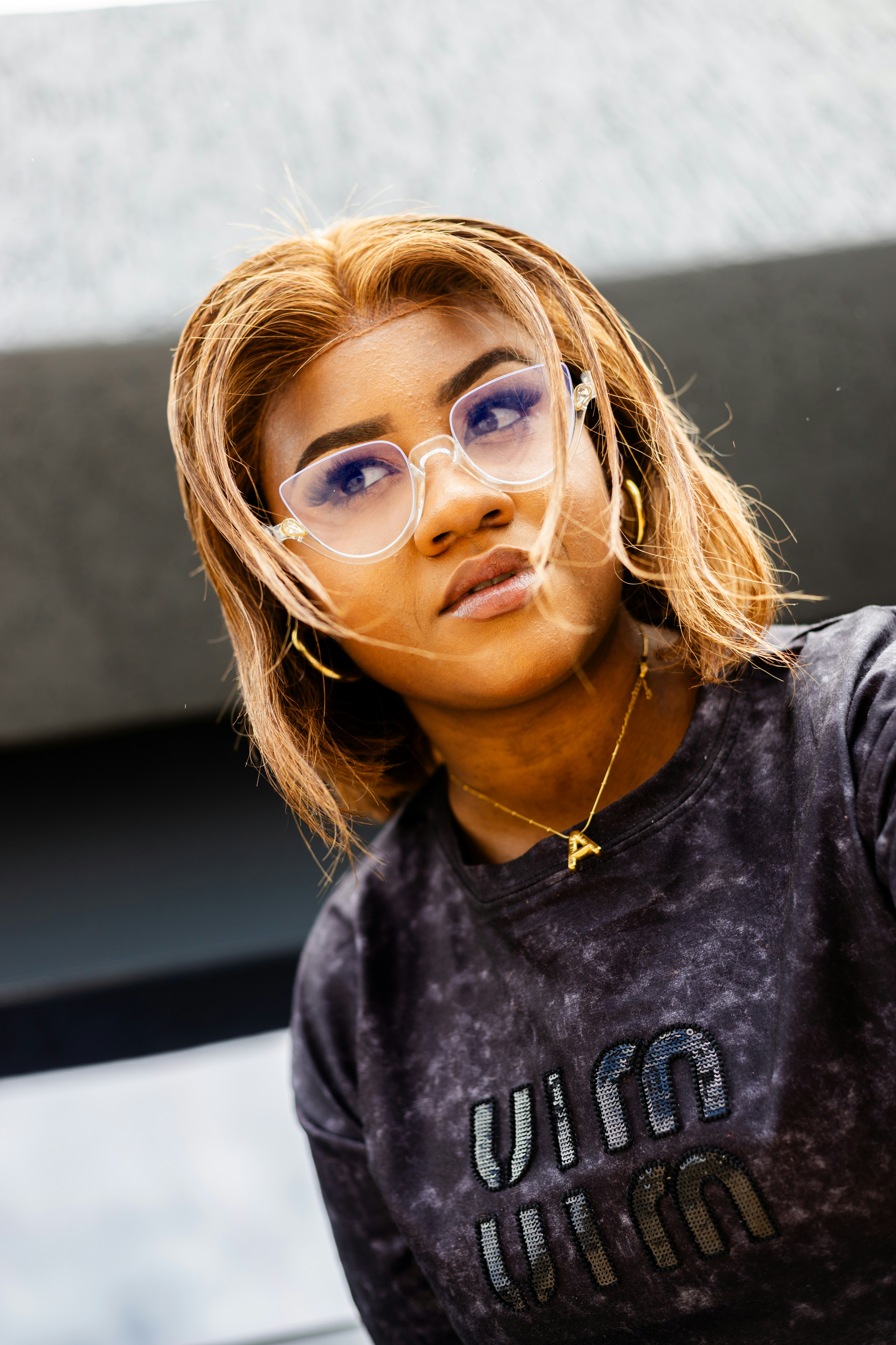 A woman with glasses and thoughtful expression.
