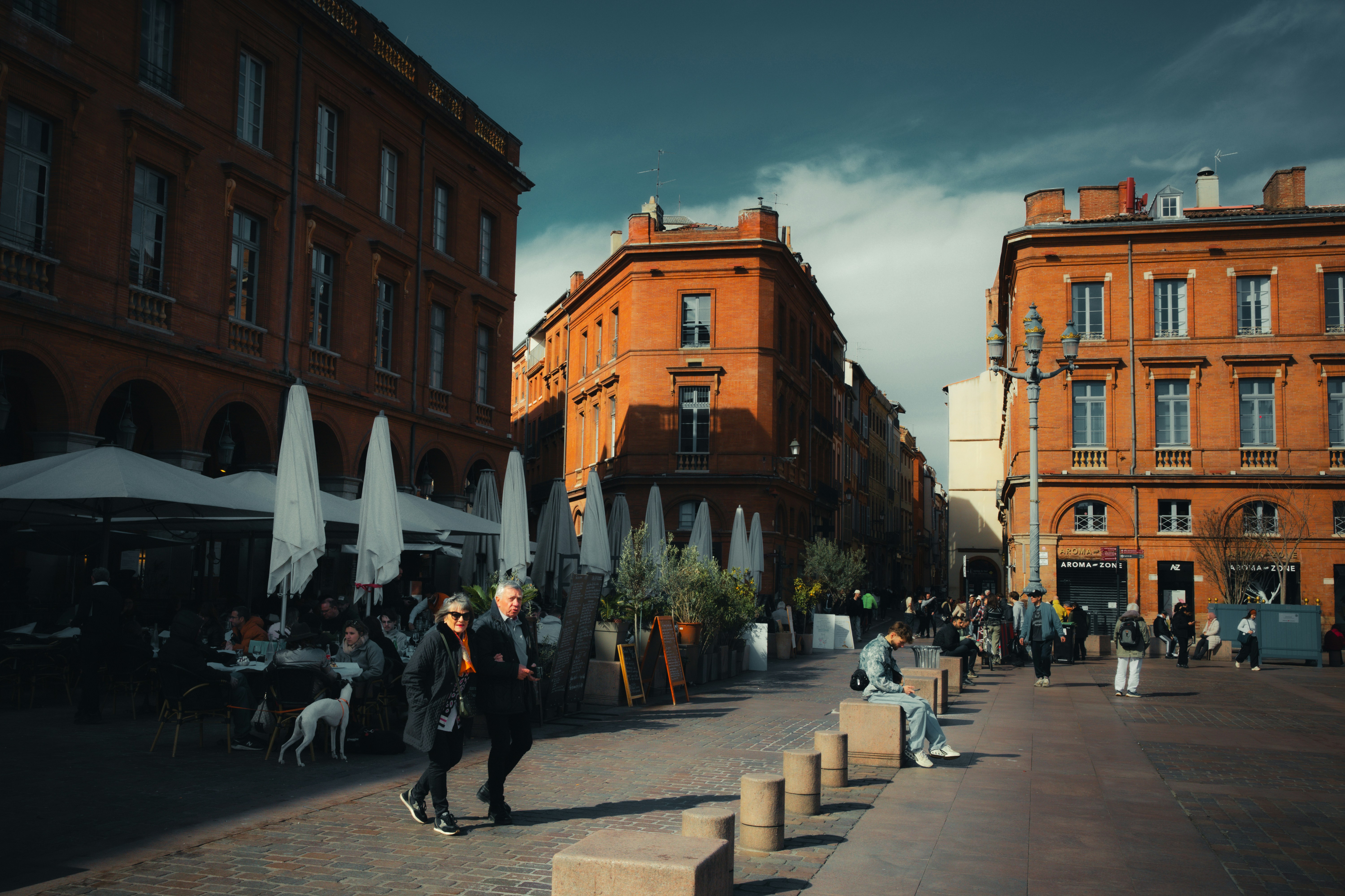 People walk through a european town square.