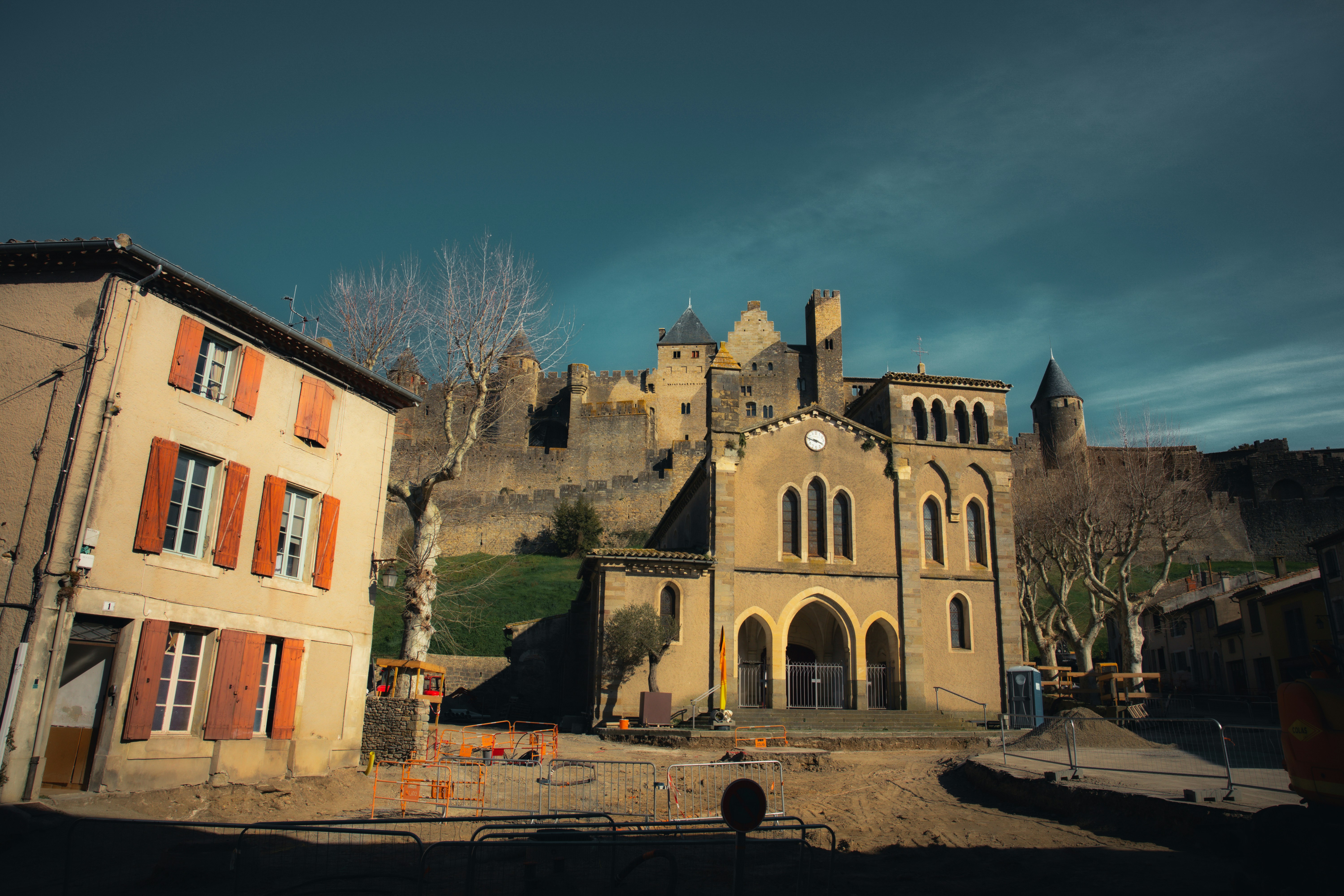 Buildings stand near a historic castle on a hill.