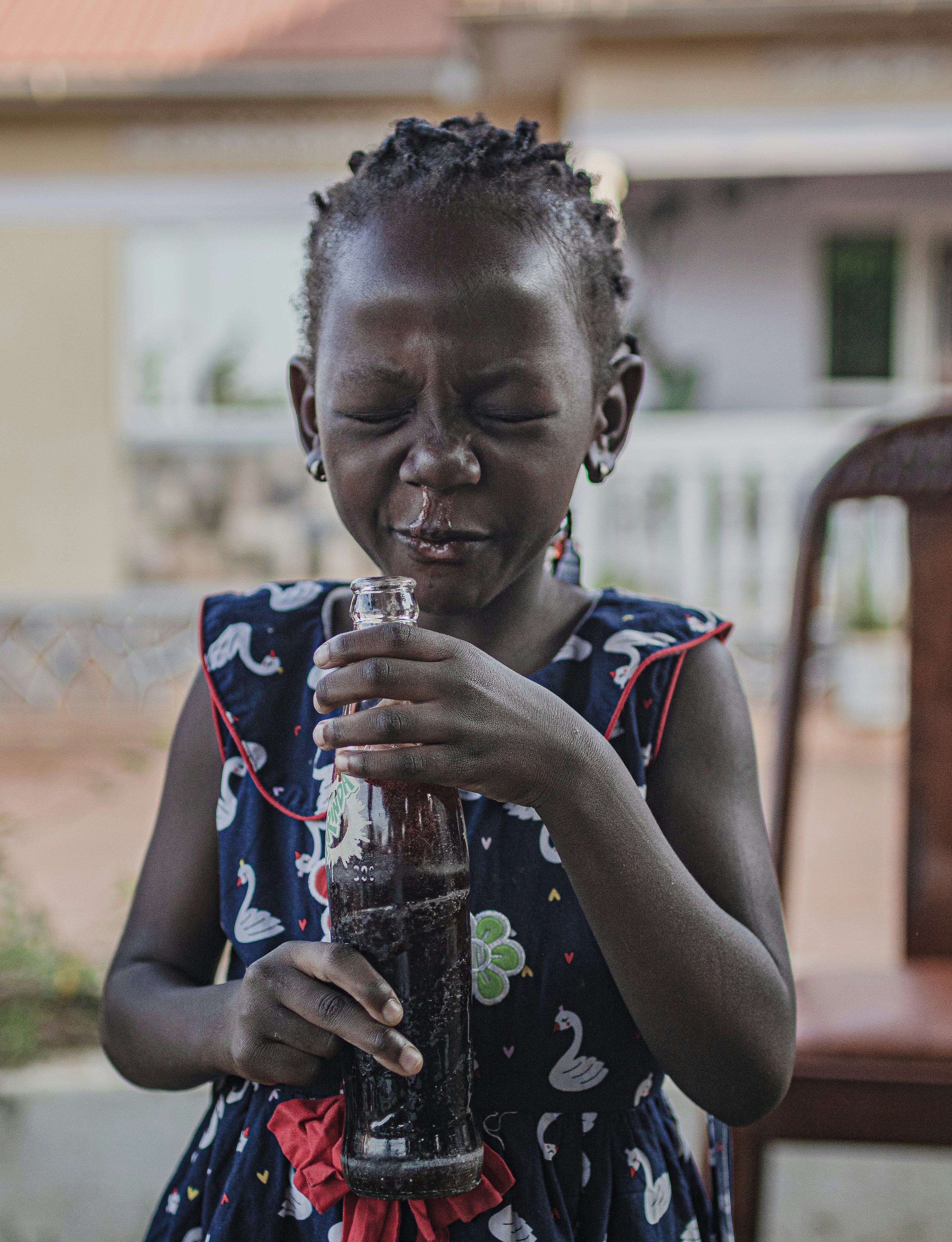 Una ragazza beve bibite gassate e fa una faccia buffa.