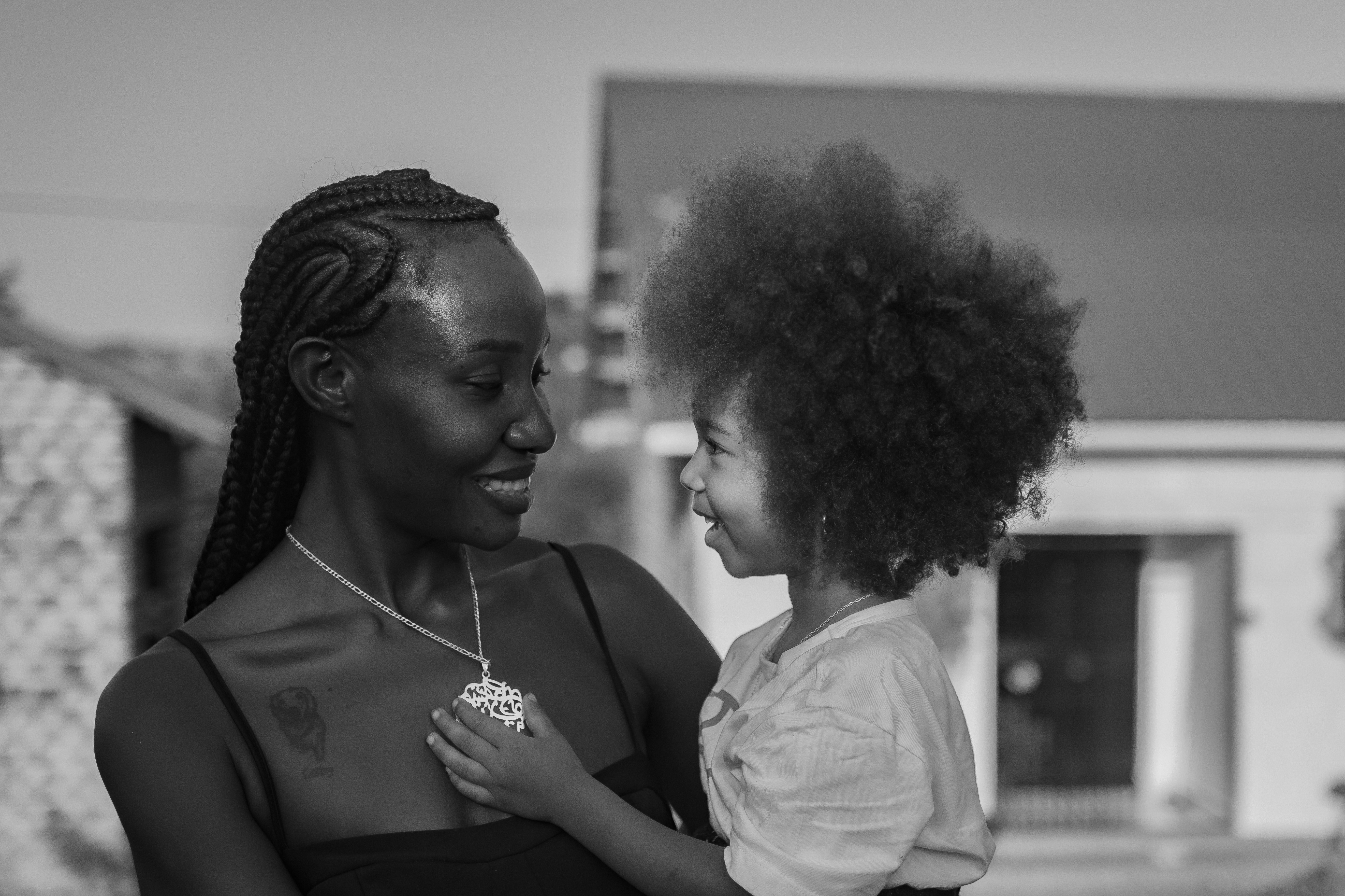A mother holds her child, smiling happily.