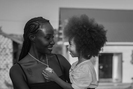A mother holds her child, smiling happily.