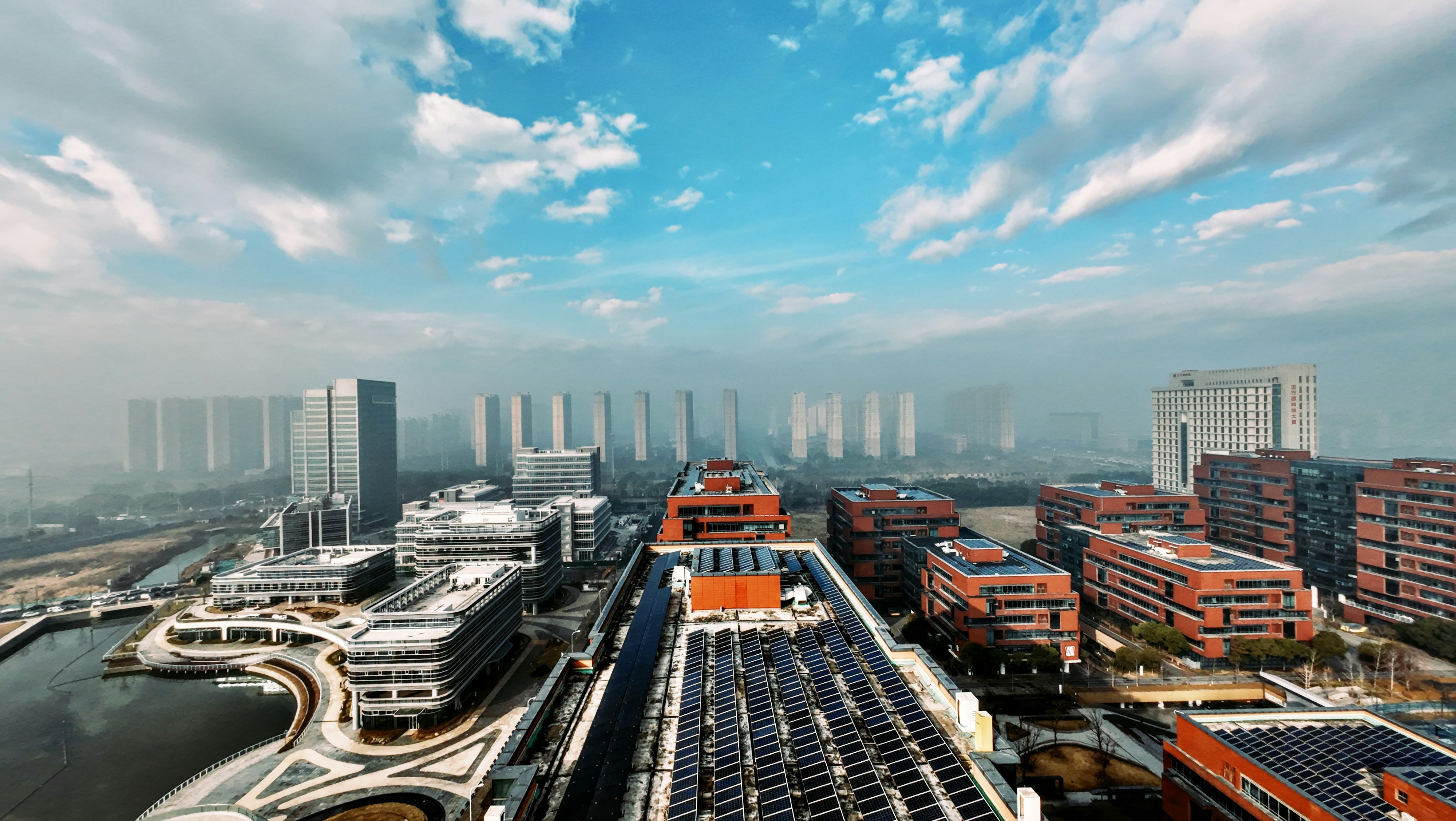 Cityscape with modern buildings under a cloudy sky.