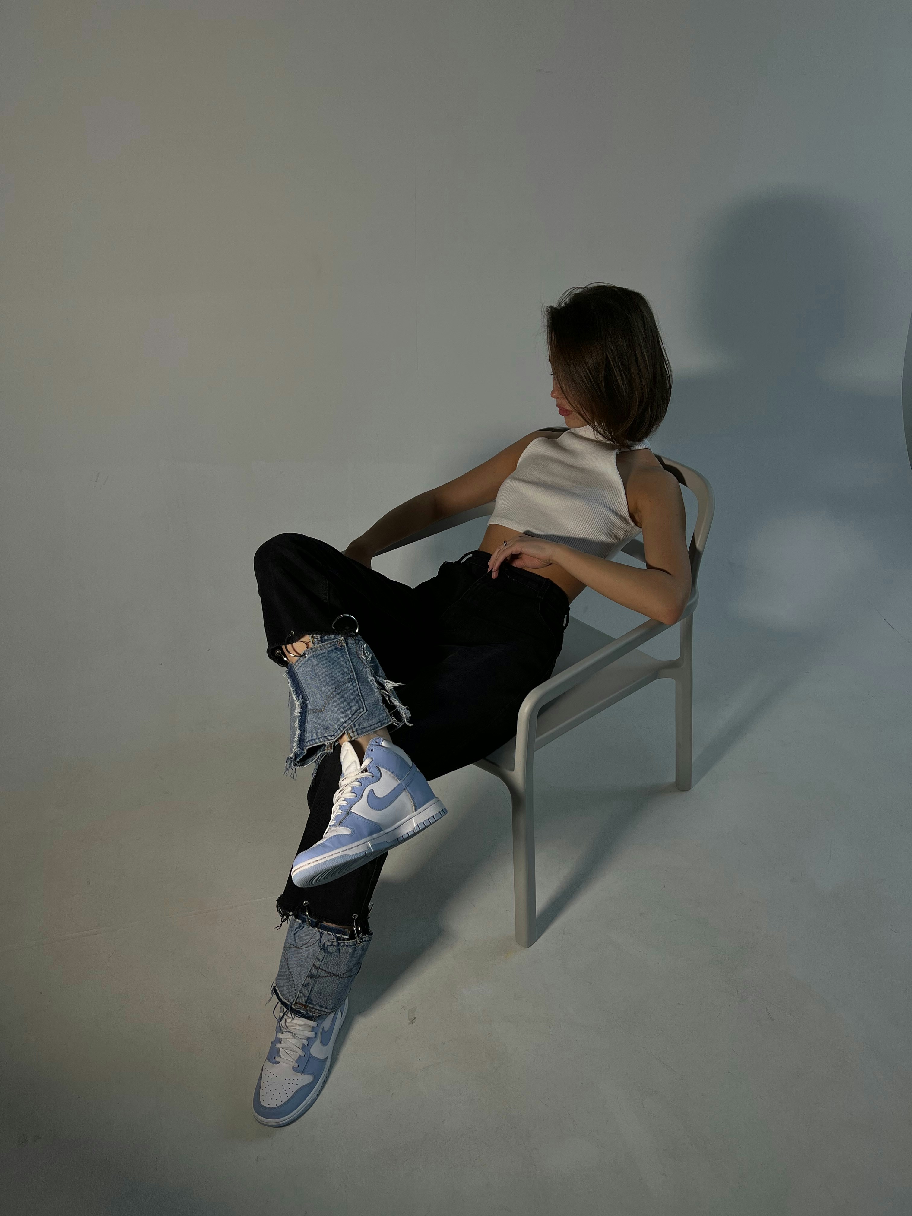 Woman sits in a chair, striking a pose.