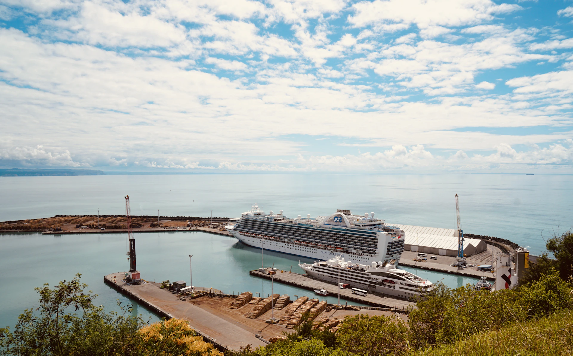 A cruise ship is docked in a calm harbor