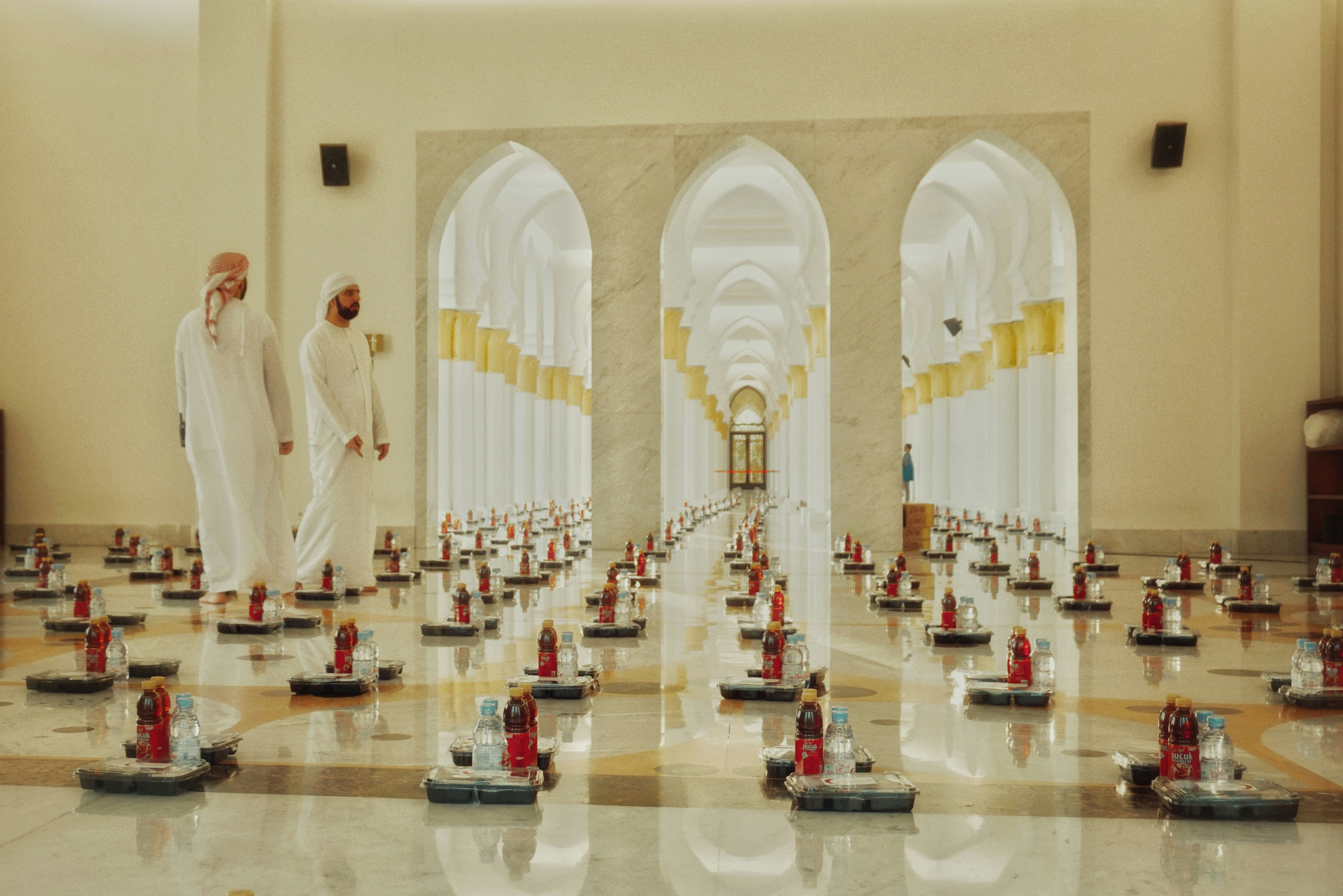Dua pria berjalan di dalam sebuah masjid.