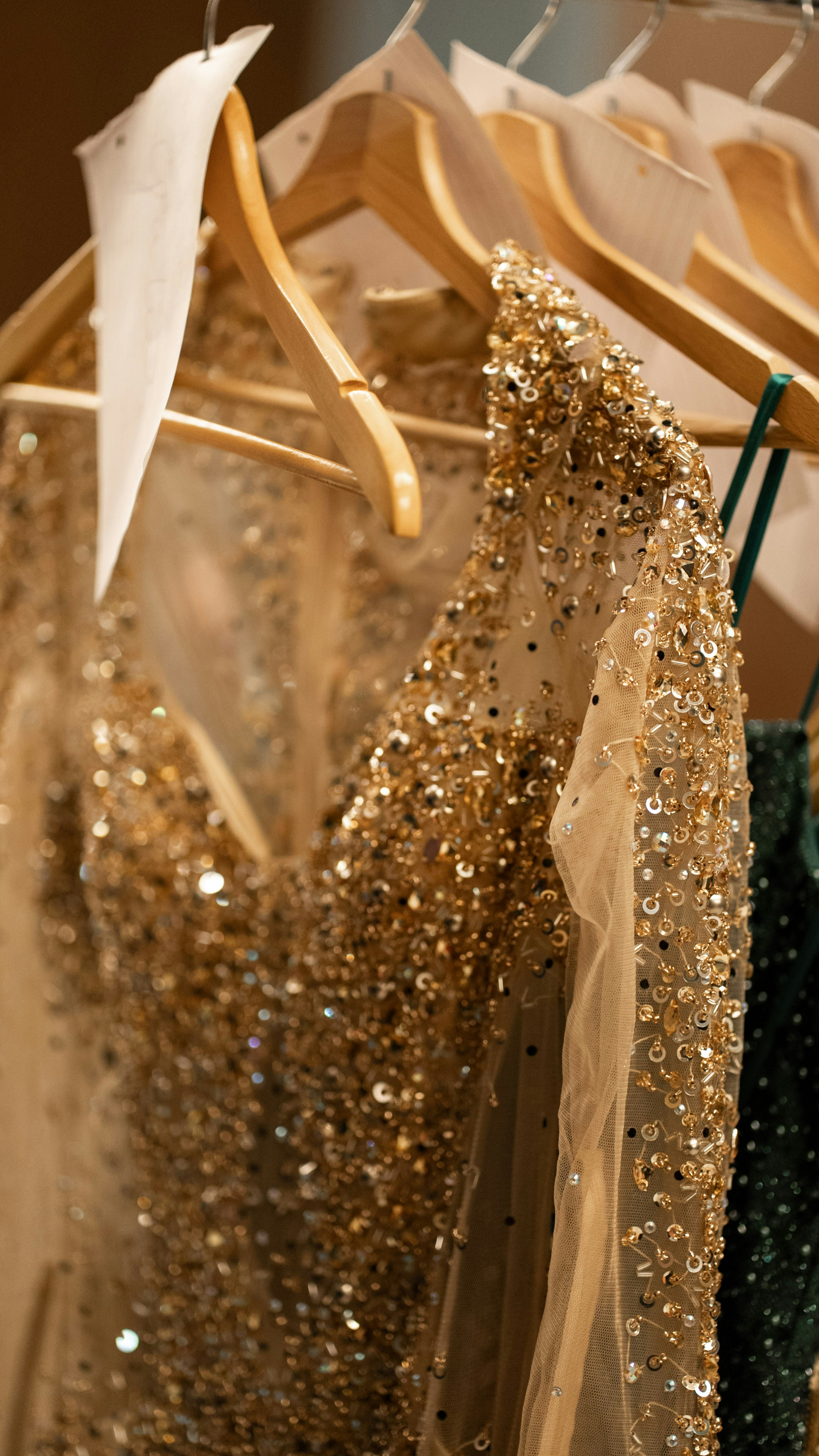 Golden, beaded dress hanging on a rack.