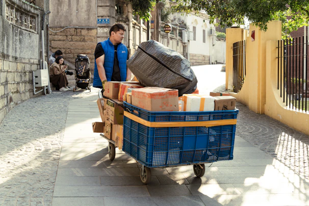 Delivery man transports packages on a cart.