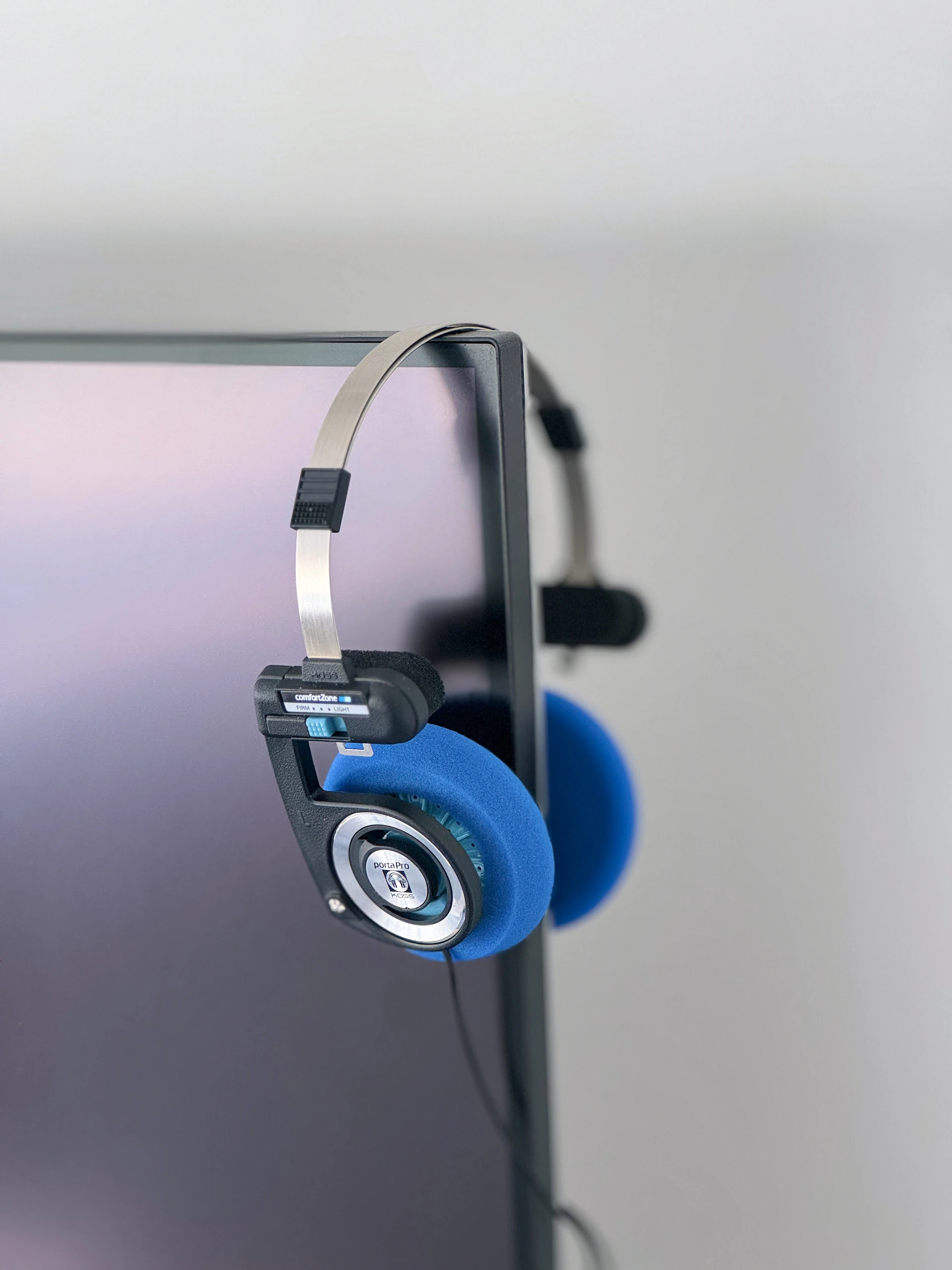 Headphones hanging on a monitor.