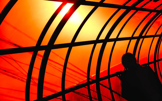 Silhouette stands near a vibrant, abstract architectural tunnel.