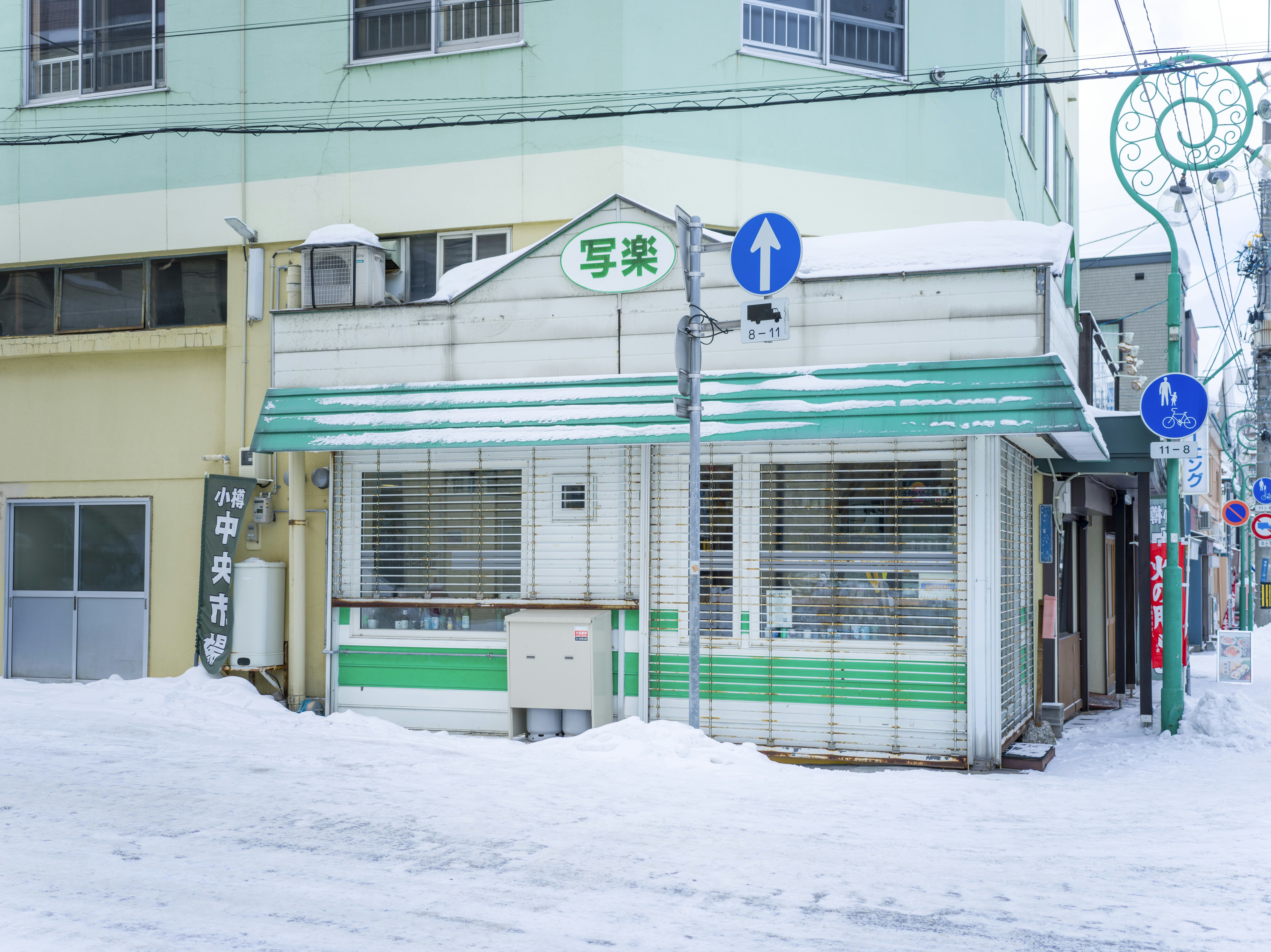 Japanese pharmacy exterior with green cross symbol