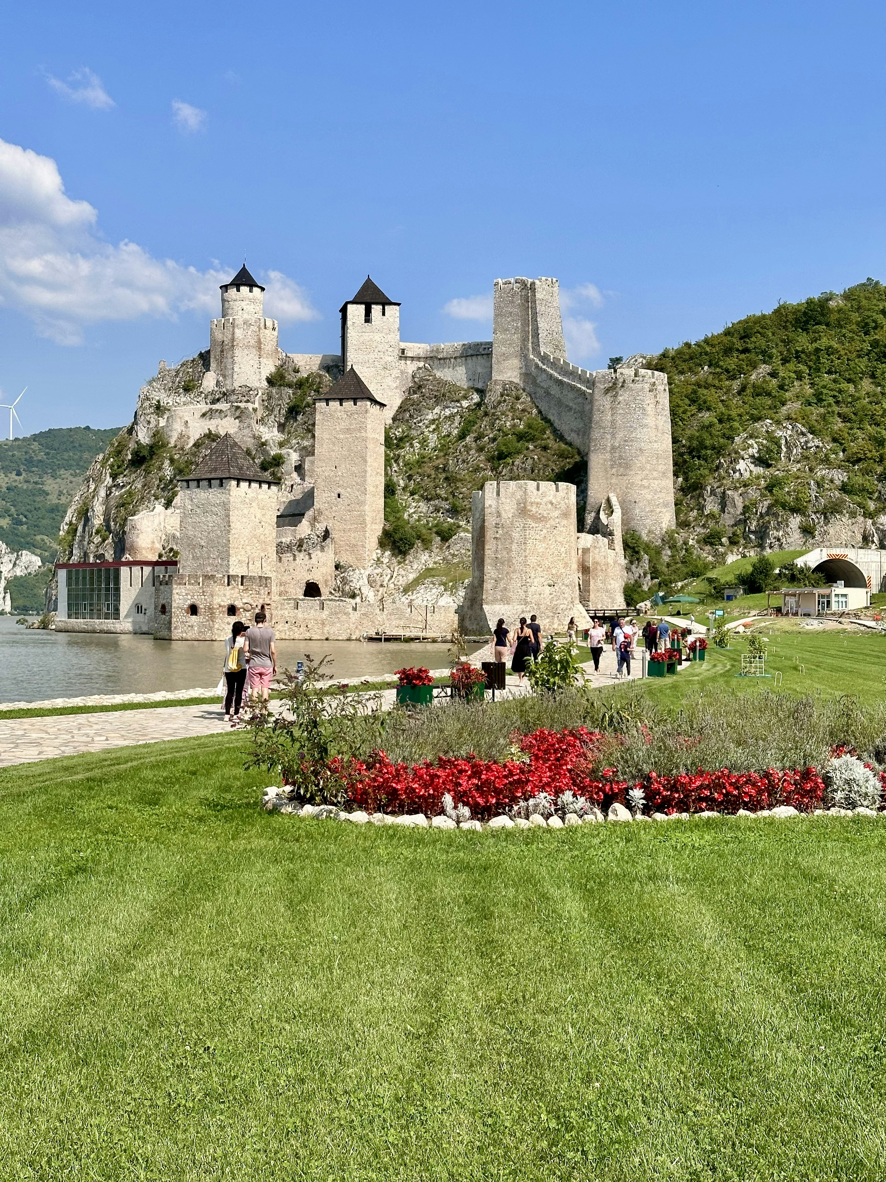 Medieval fortress stands on a hill near the water.
