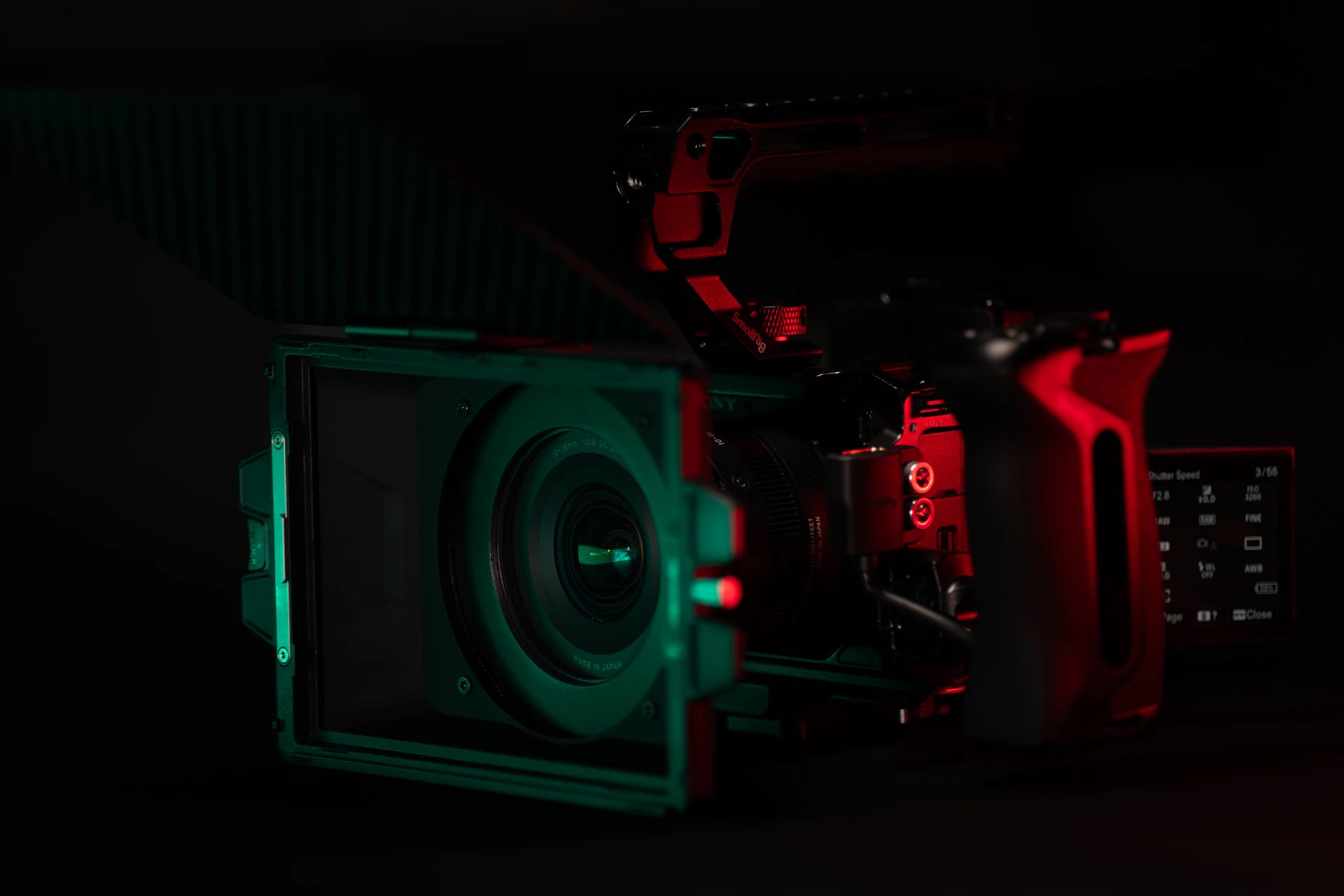 A professional camera is illuminated with red and green light