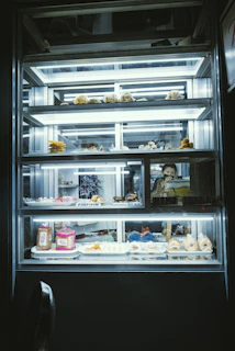 A lit display case of baked goods.