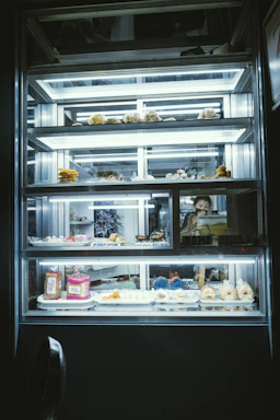 A lit display case of baked goods.