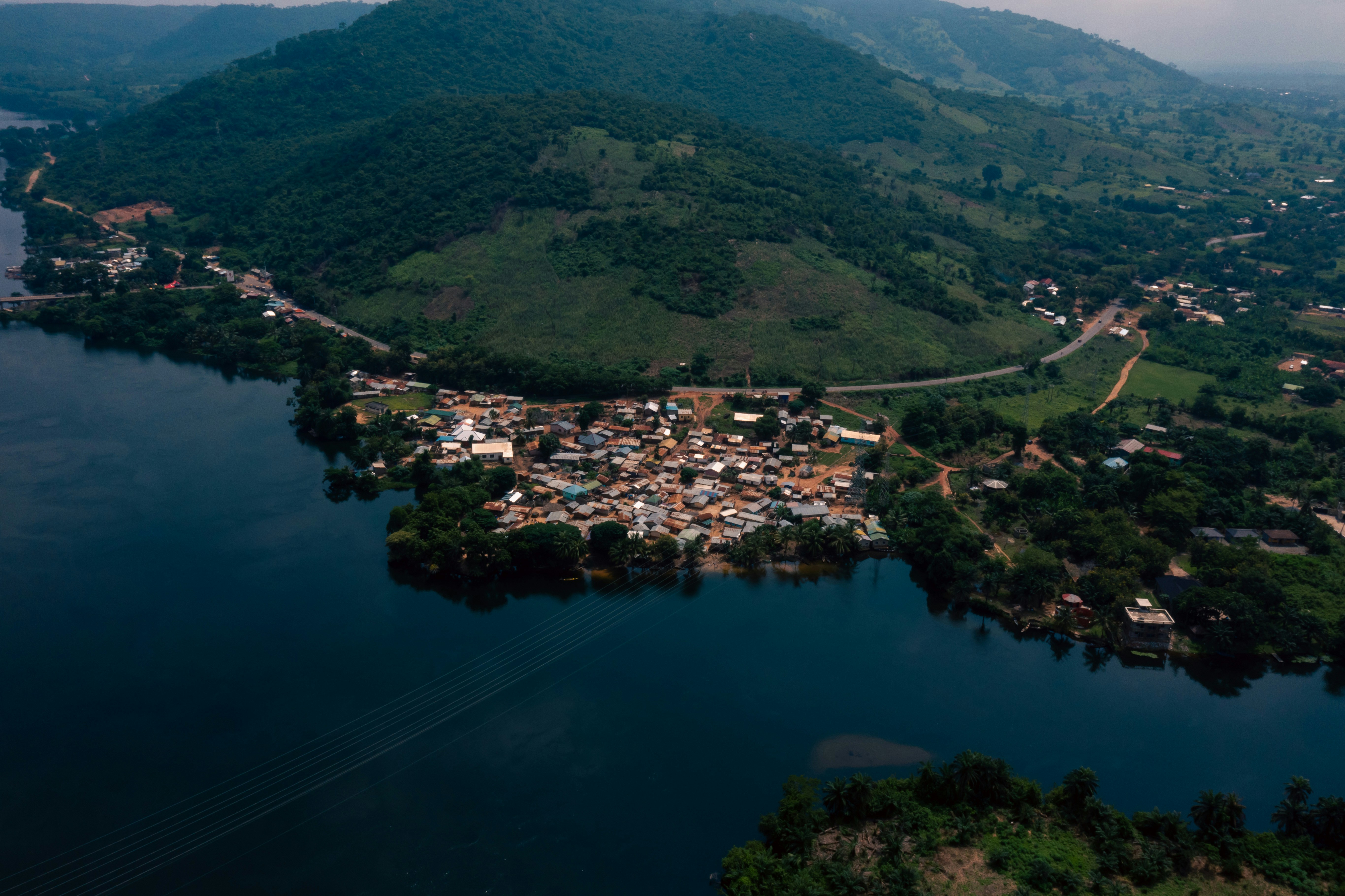 Aerial view of Akosombo on a peninsula in the Volta, with forested hills rising behind the town