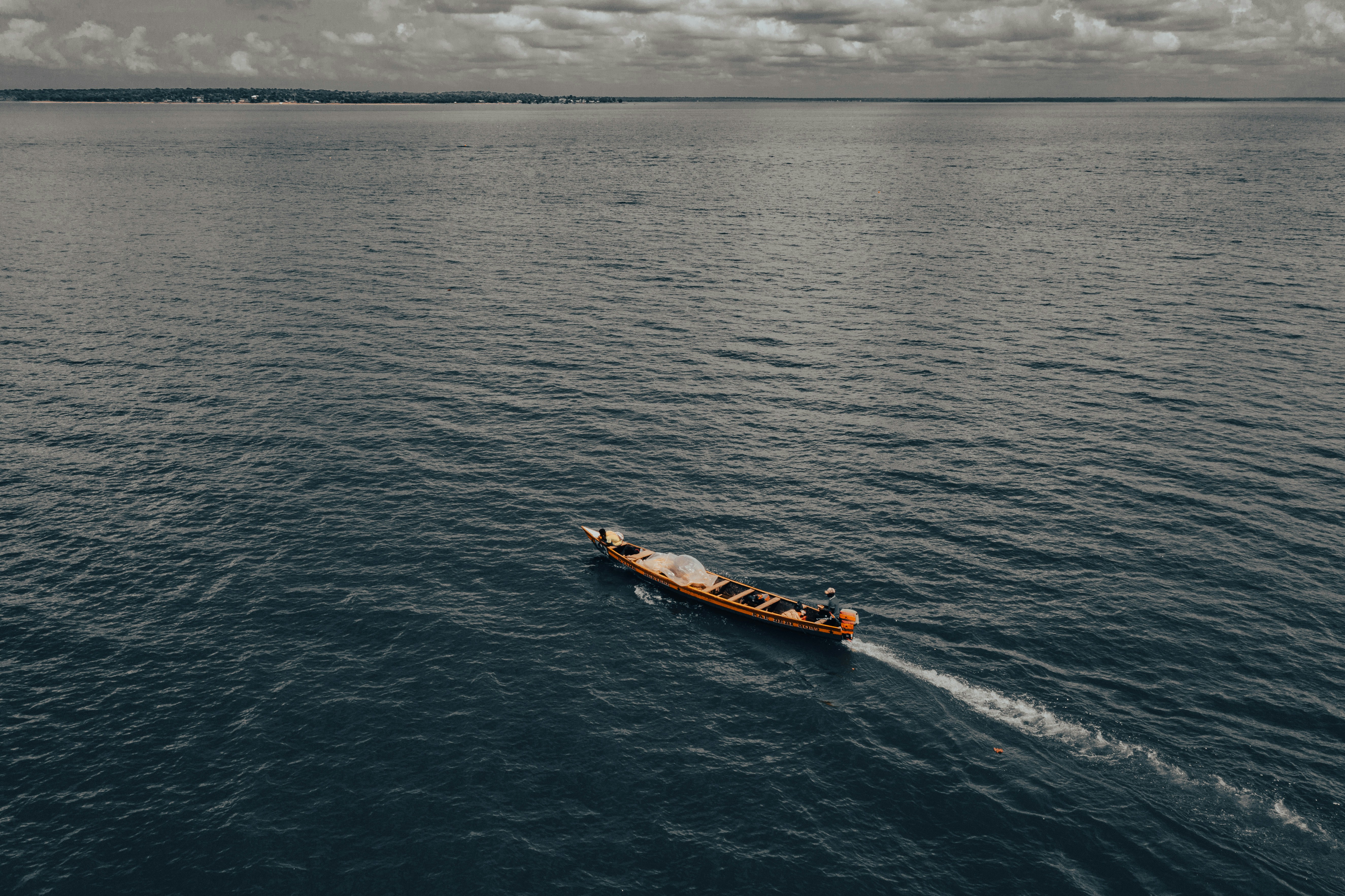 Un bateau navigue sur un océan bleu et calme.