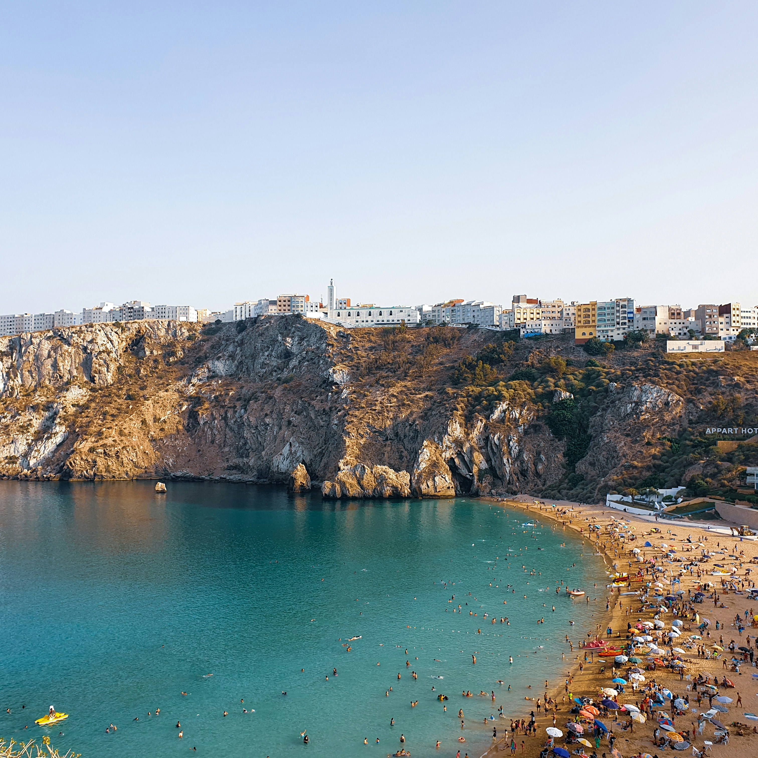 Ein wunderschöner Strand mit Klippen und einer Stadt.
