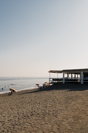 Beach umbrellas and a cafe on a sandy beach.