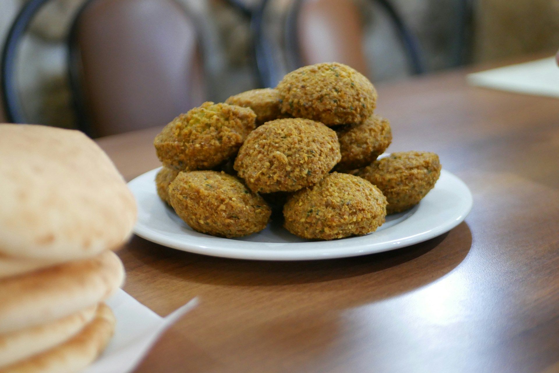 Falafel and pita bread are displayed on a table.