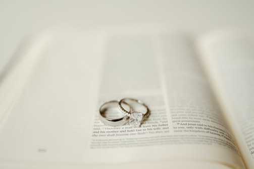 Wedding rings rest upon an open book.
