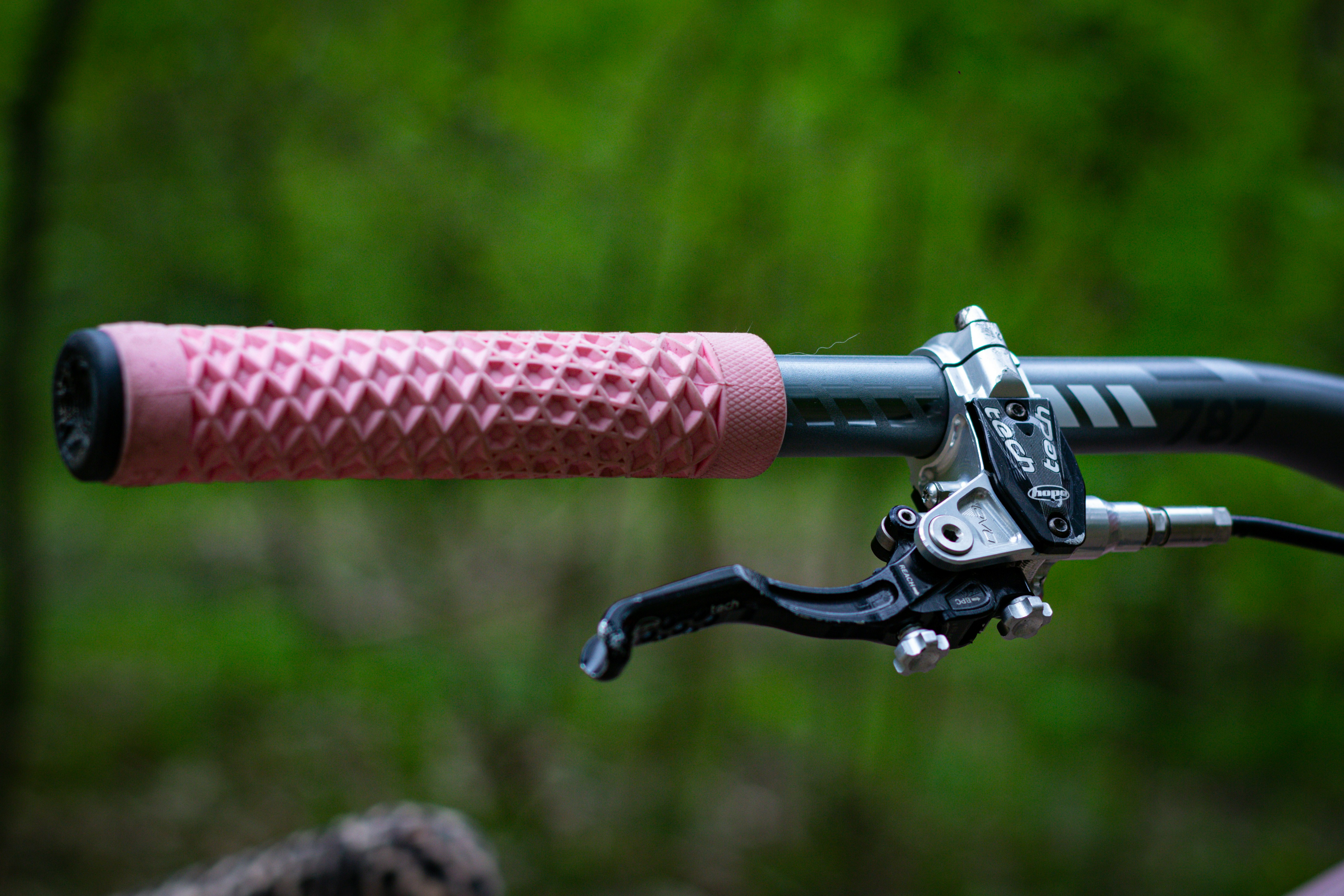 Pink bike grip with brake lever detail.