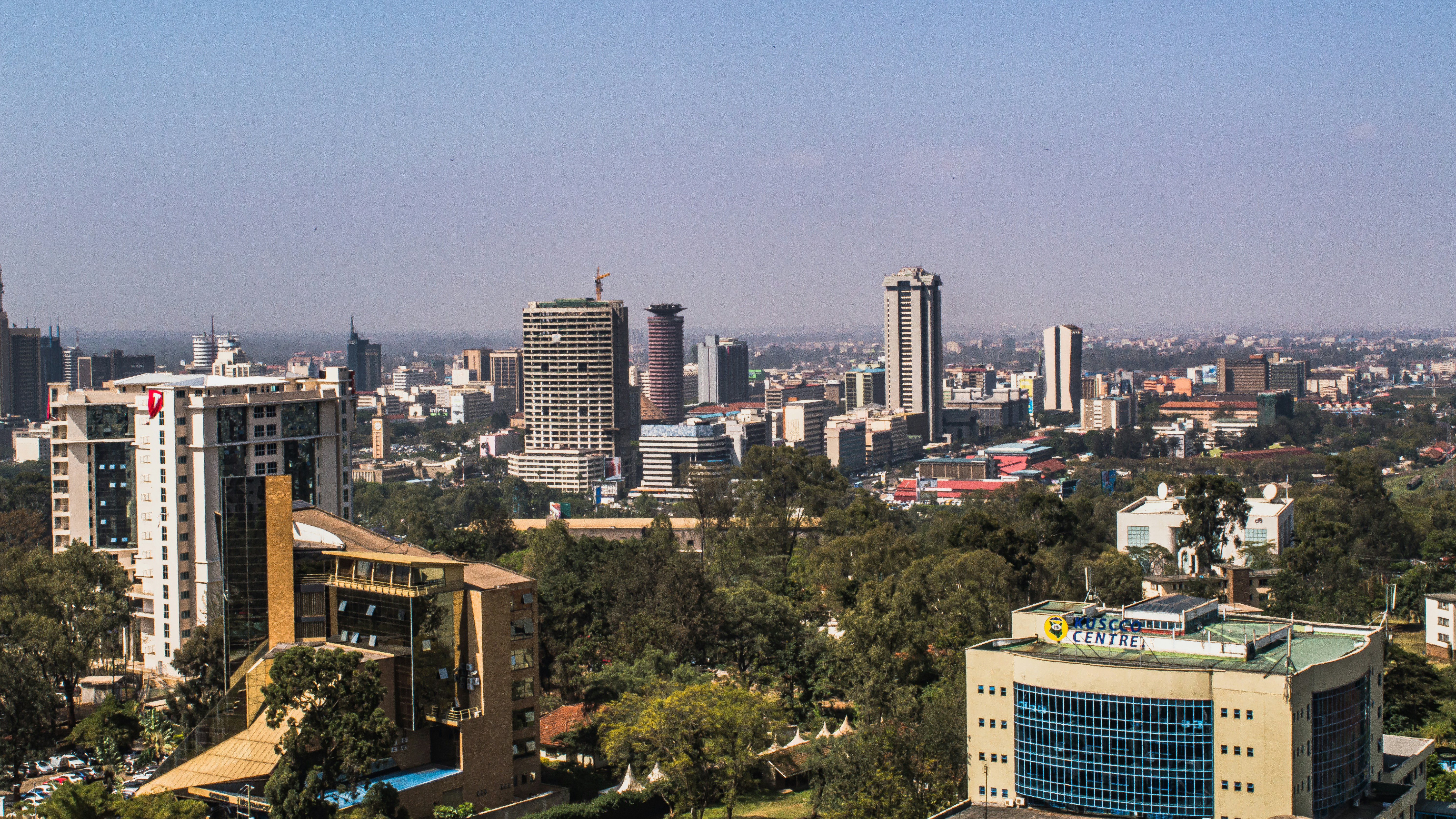A panoramic shot of Nairobi's skyline, showcasing the juxtaposition of modern skyscrapers and lush greenery