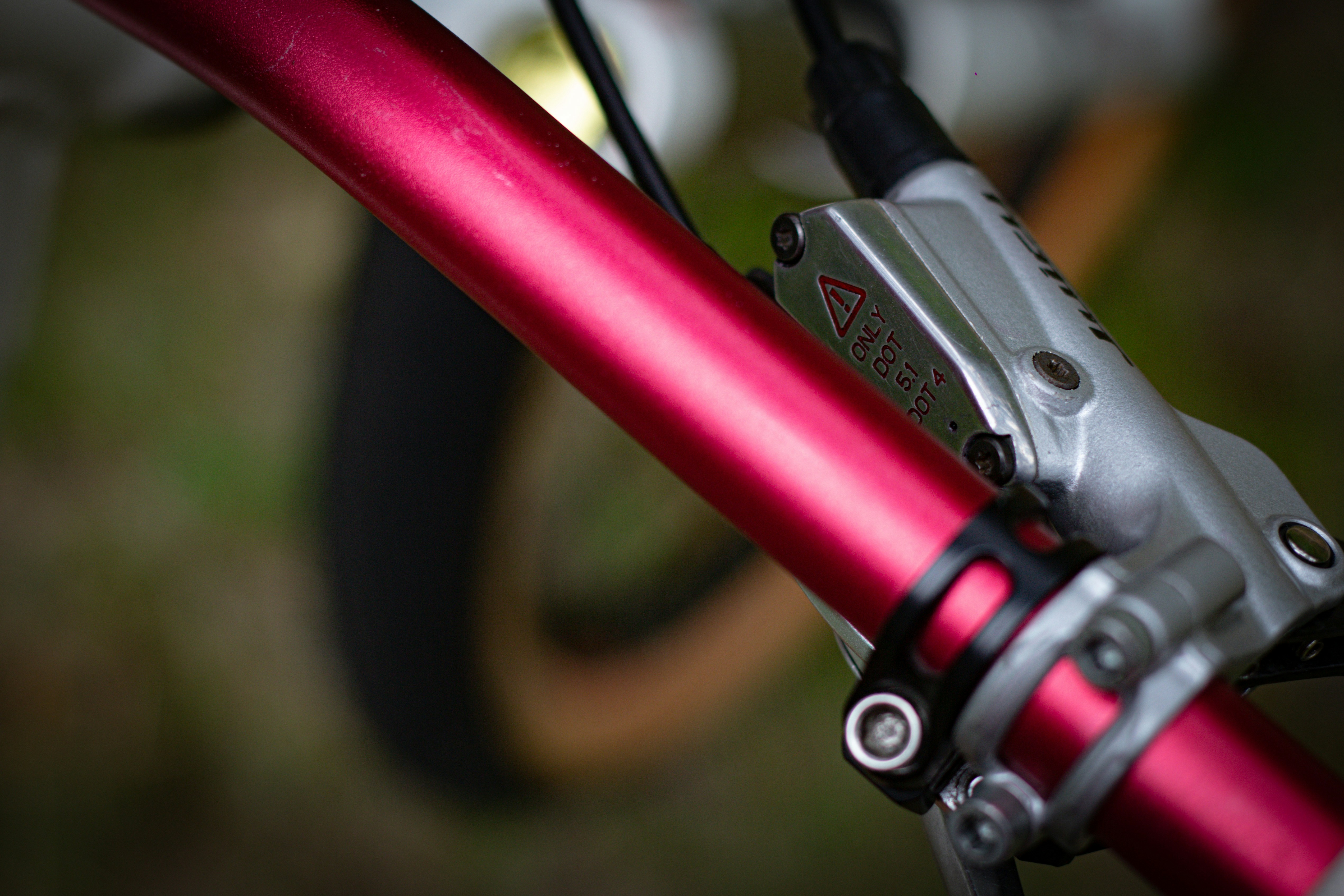 A red bicycle handlebar and brake system.
